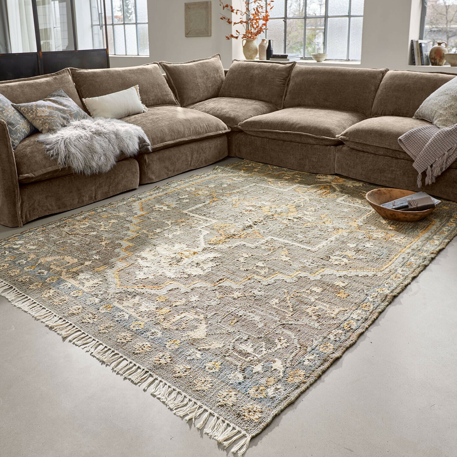 Teppich Brenrin Großer Teppich mit Fransen in beige-grauem orientalischem Muster vor braunem Ecksofa
