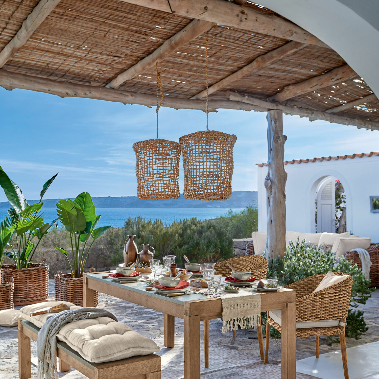 Gartenmöbel-Set aus Holz und Rattan in Naturtönen mit Meerblick und mediterranem Ambiente