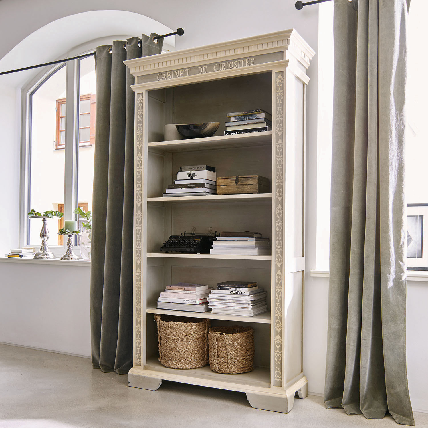 Weiße Holzvitrine mit dekorativem Schriftzug und geflochtenen Körben, Vintage-Stil fürs Wohnzimmer
