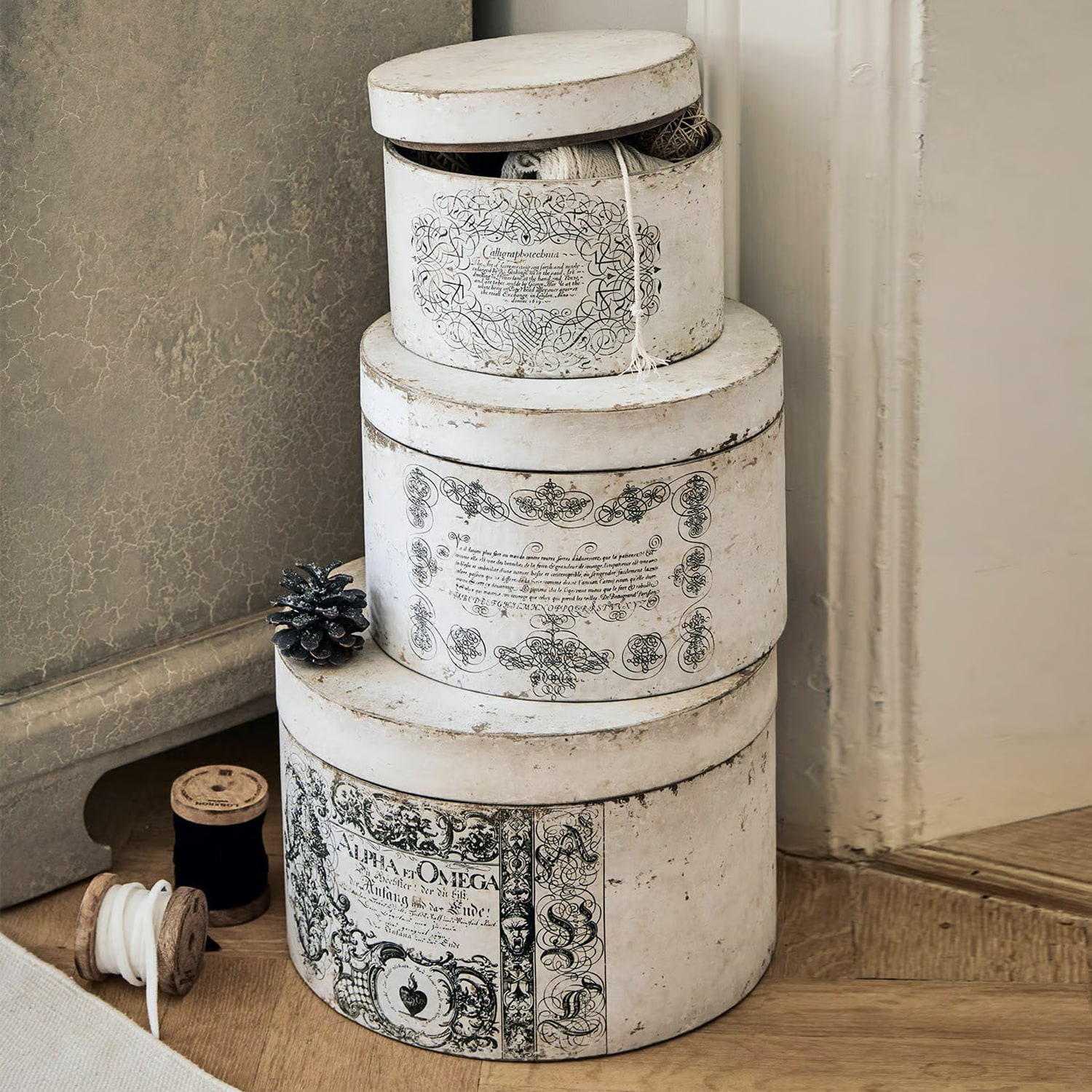 Drei runde Vintage-Papierboxen in Weiss mit schwarzen Verzierungen als dekorative Aufbewahrung