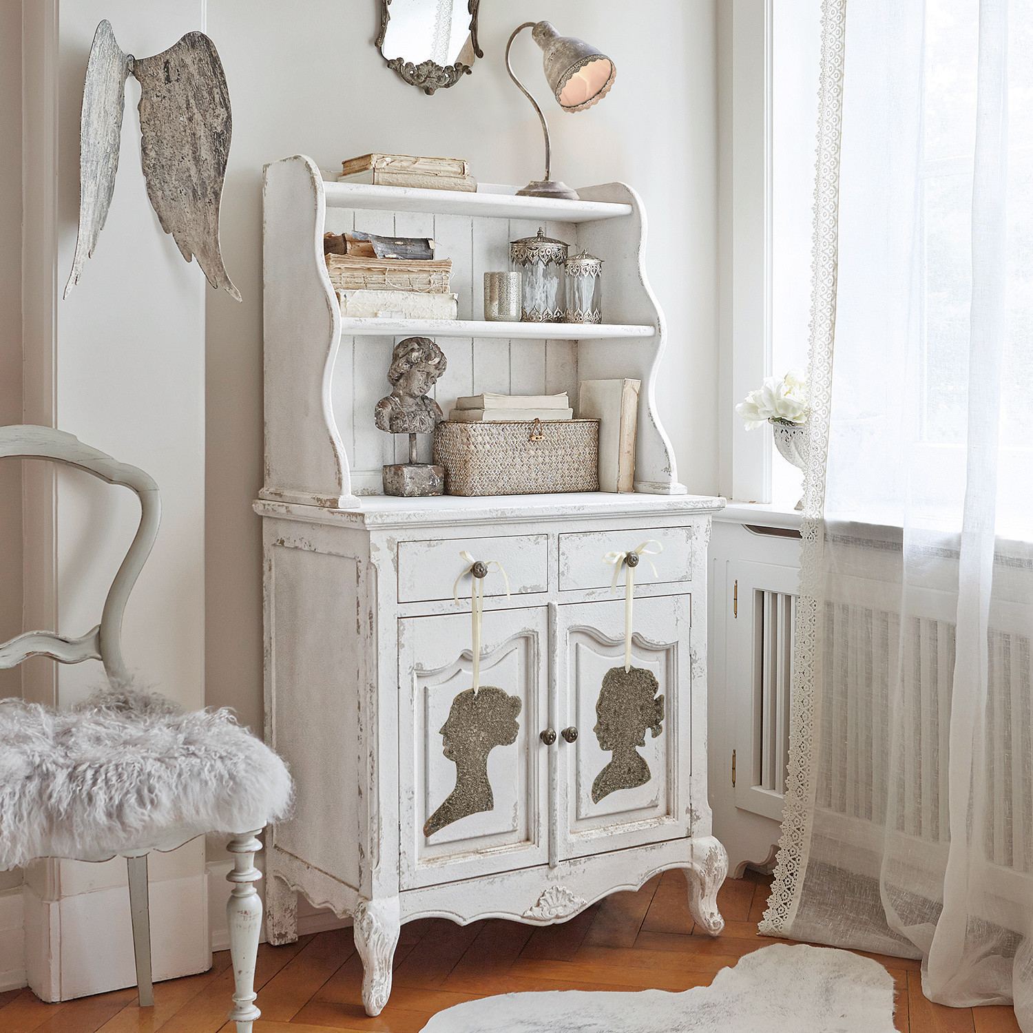 Weißer Vintage-Holzschrank mit dekorativen Silhouetten und Regalen im Shabby-Chic-Stil