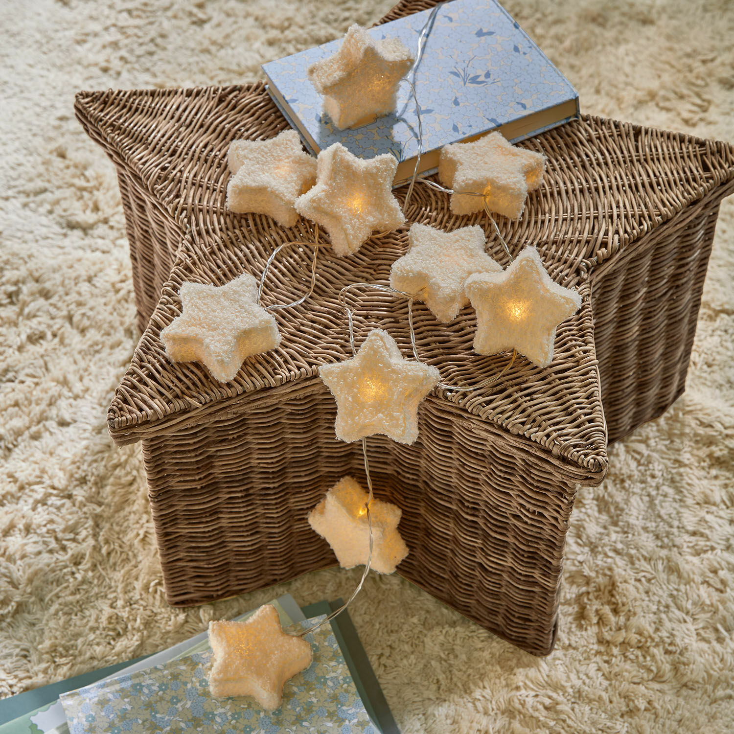 Lichterkette Starwhisper Sternförmige Lichterkette aus weichem Material mit warmem Licht auf einem Rattankorb, Wohnaccessoire