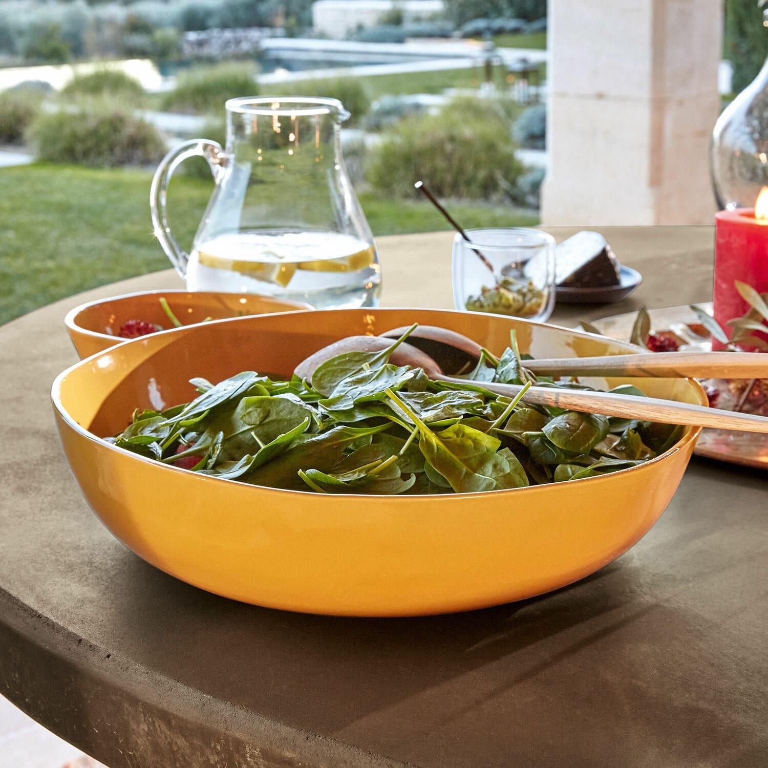 Schüssel Calvi Gelbe Keramik-Salatschüssel mit Holzbesteck auf Gartentisch im Freien