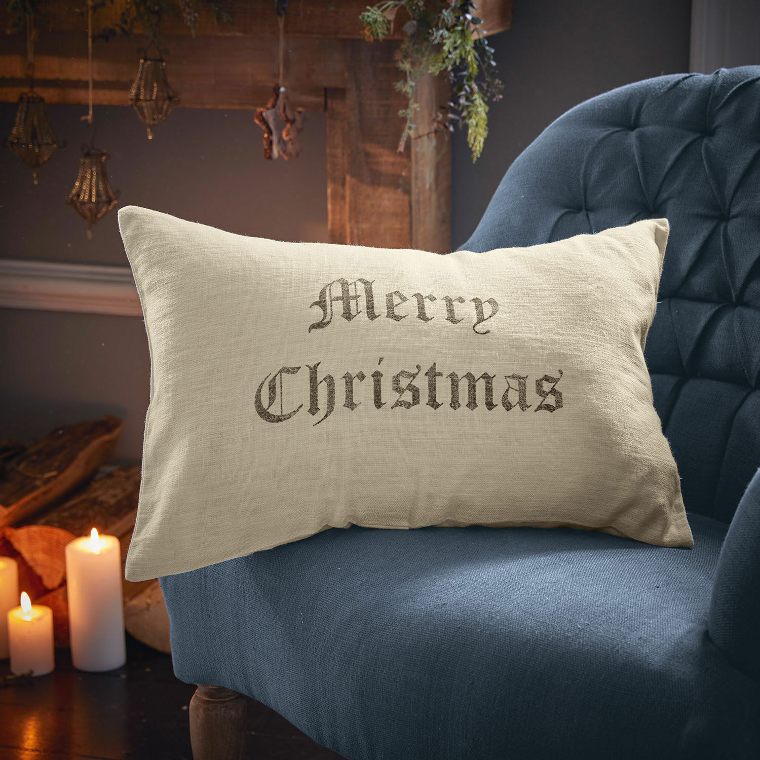Kissenhülle Merry Christmas Beige Leinenkissen mit Schriftzug Merry Christmas auf blauem Sessel, weihnachtliche Dekoration
