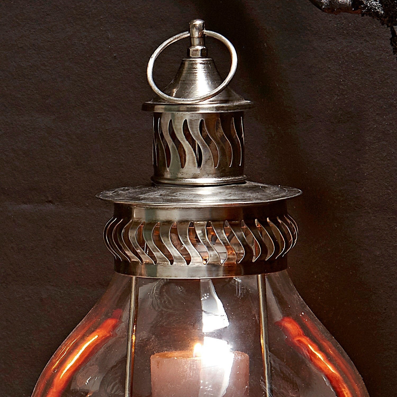 Metalllaterne mit klarem Glas und brennender Kerze, dekoratives Wohn- und Gartenelement