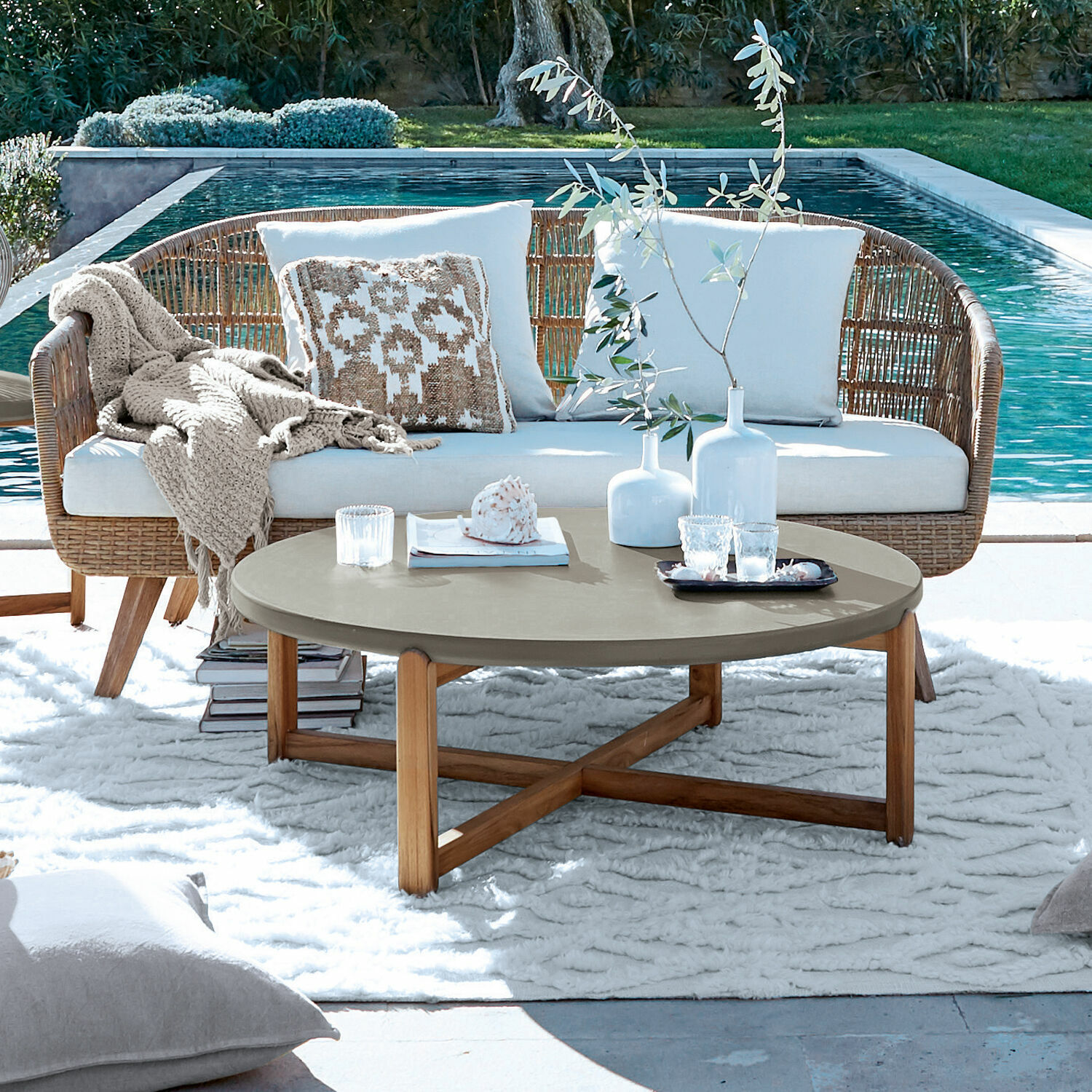 Couchtisch Robinson Runder Couchtisch mit grauer Tischplatte und Holzgestell auf Terrasse am Pool