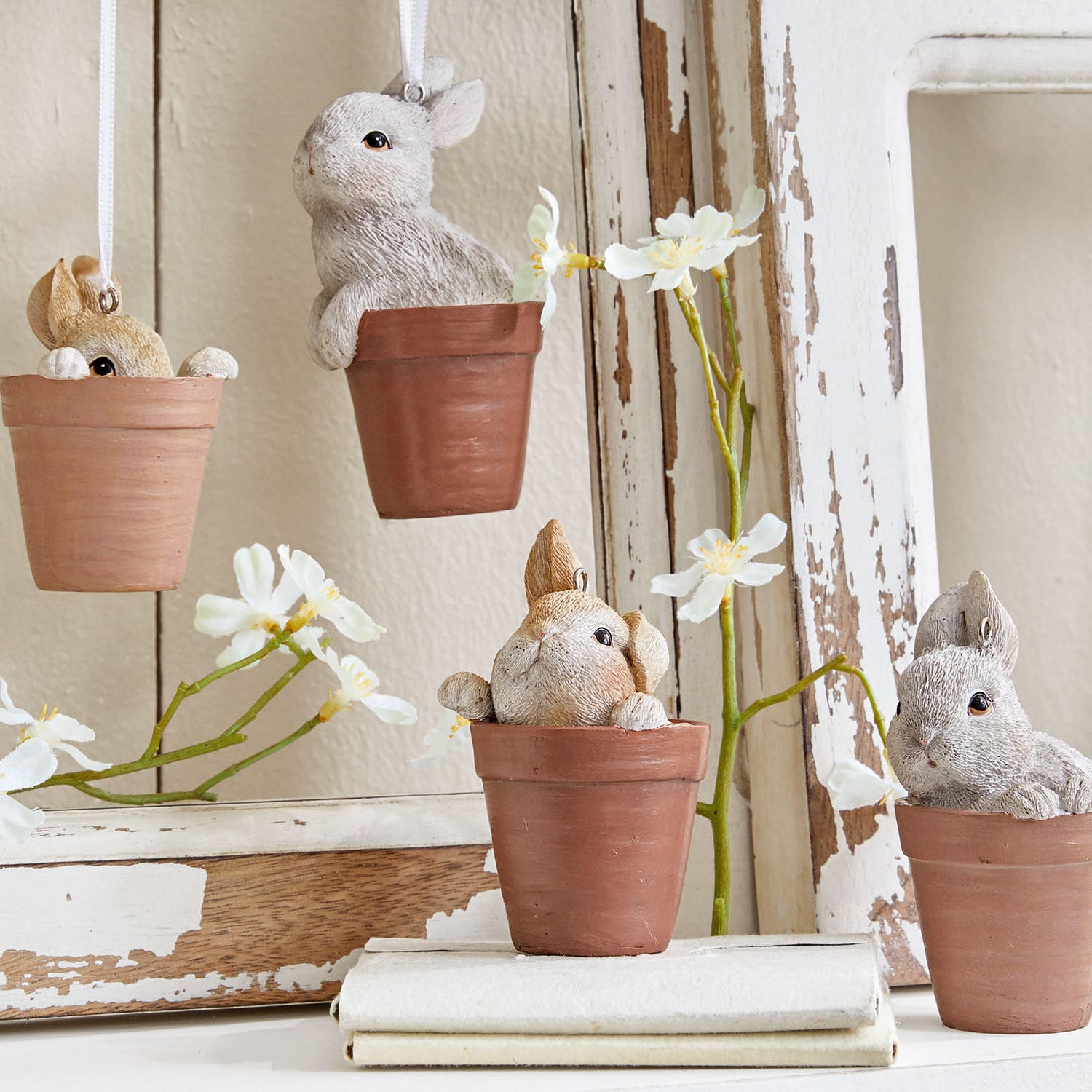 Dekorative Hasenfiguren aus Keramik in braunen Blumentöpfen für Frühlingsdeko