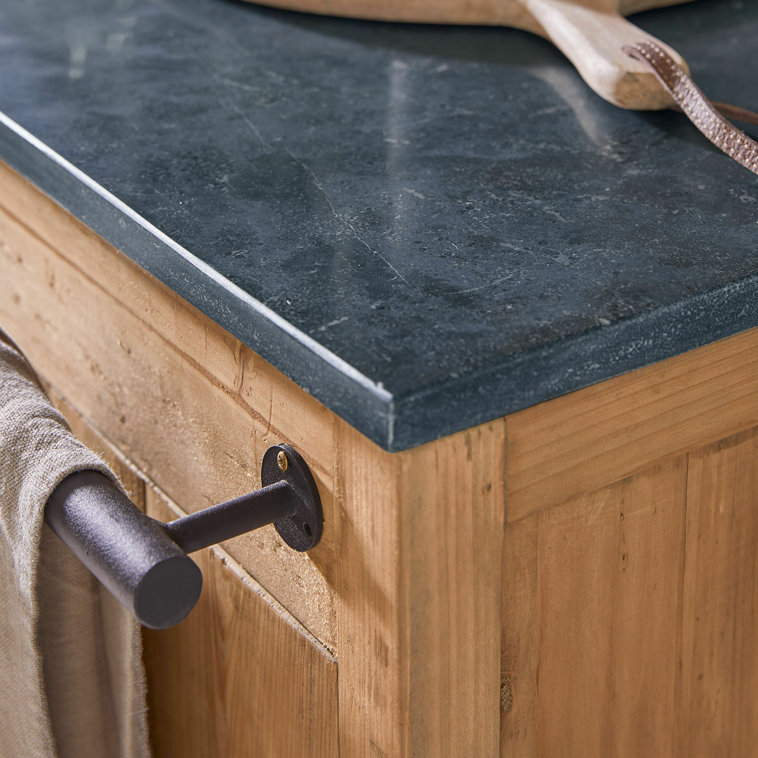 Dunkle Stein-Arbeitsplatte auf Holzschrank mit schwarzem Metall-Handtuchhalter