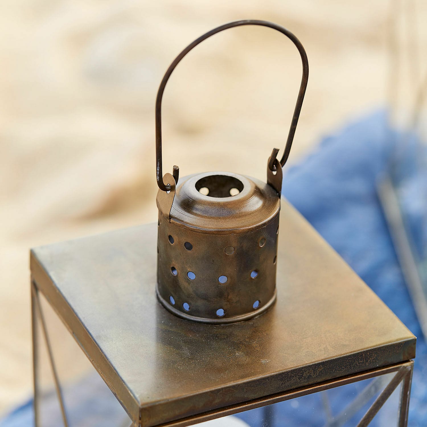 Metallhalter mit Löchern in Rostoptik auf Metalltisch, Gartendekoration