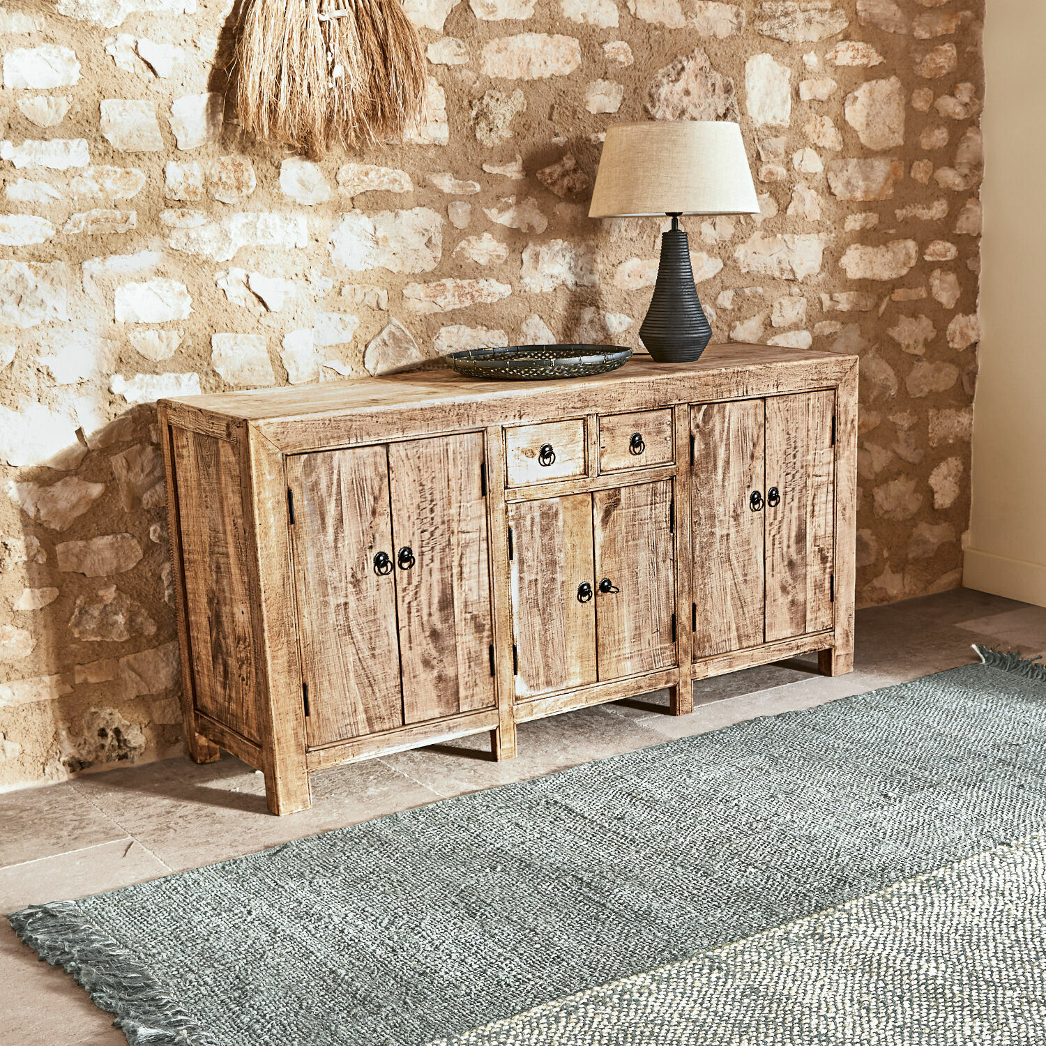 Rustikales Sideboard aus Mangoholz in Naturfarbe mit Lampe und Teppich im Wohnzimmer