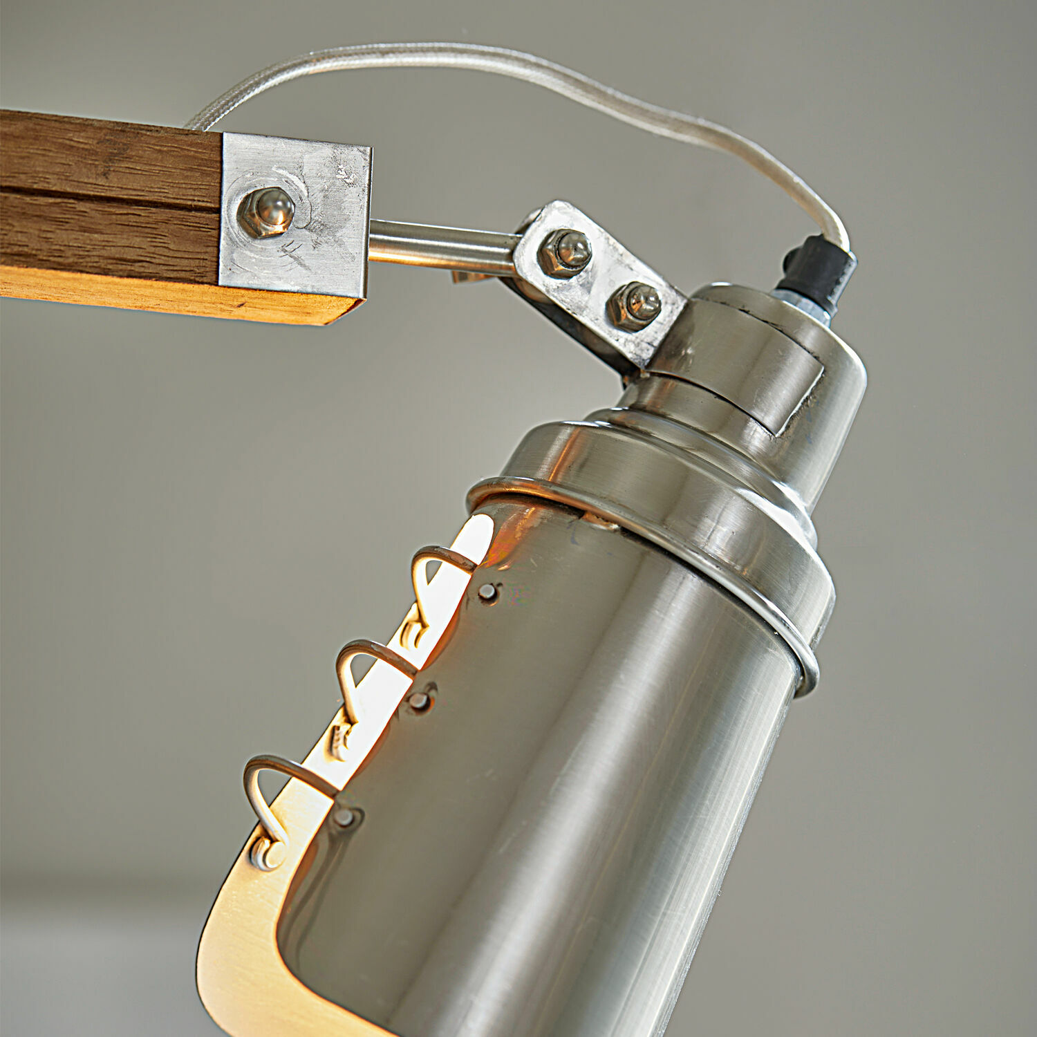 Metalllampe mit silbernem Schirm und Holzarm zur Innenbeleuchtung