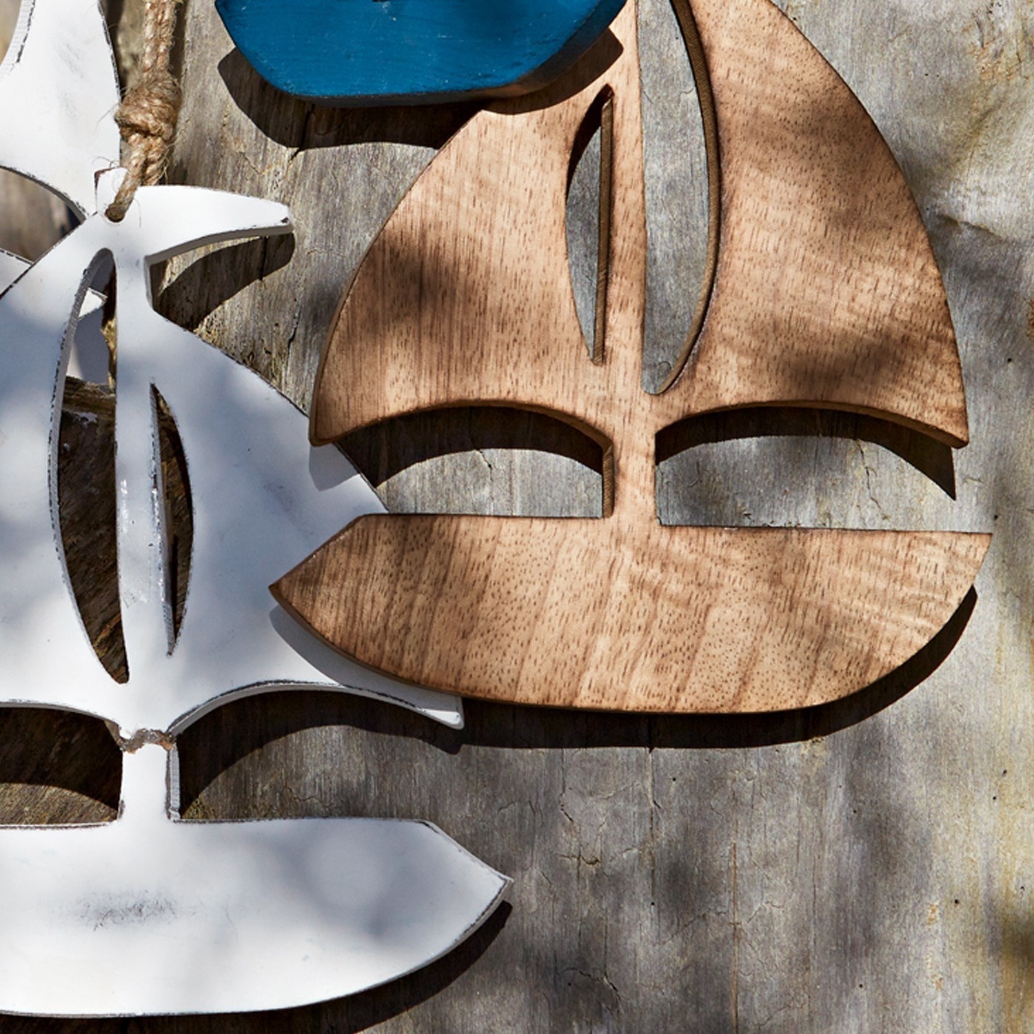 Wanddekoration aus Holz und Metall in Segelbootform in Natur- und Weißtönen