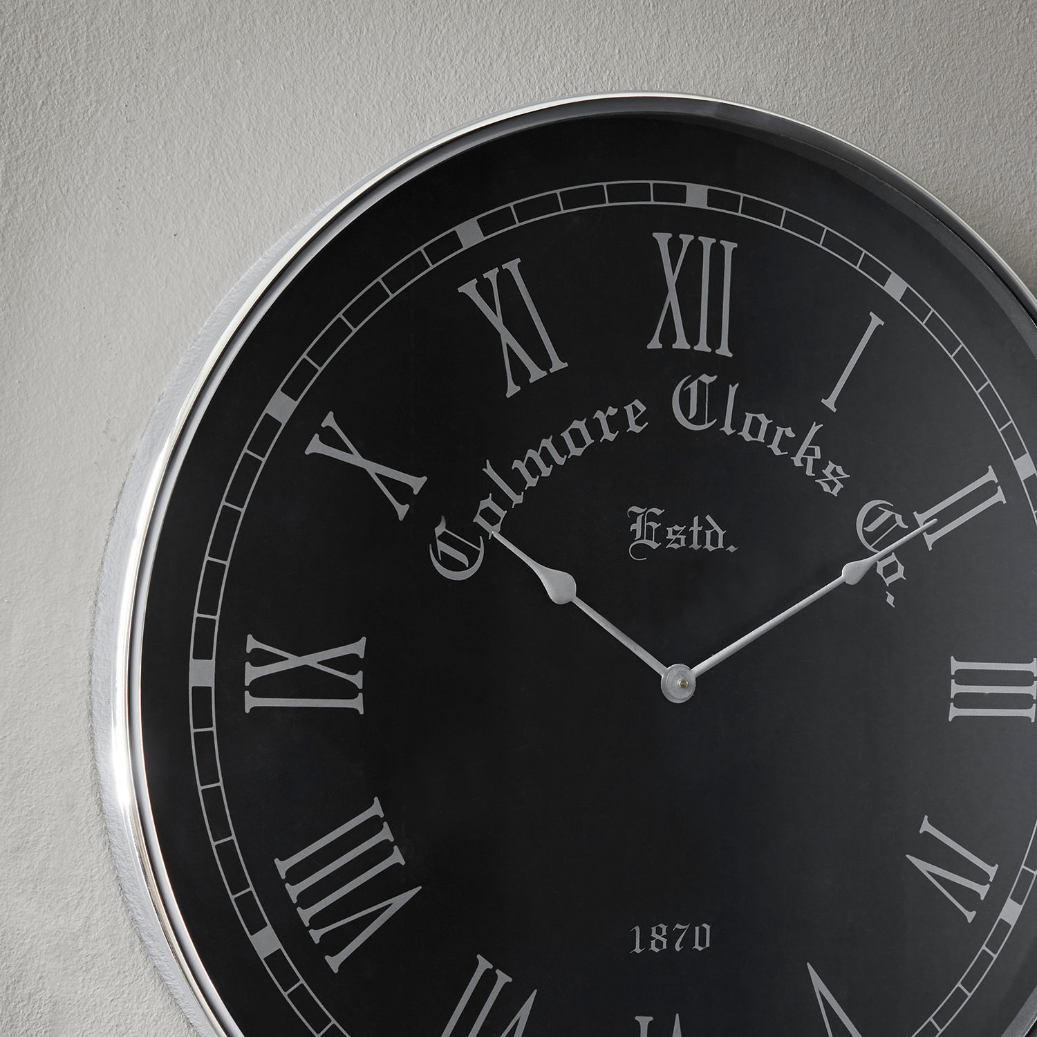 Schwarze Wanduhr mit weißen römischen Ziffern und Metallrahmen für Wohnraumdekoration