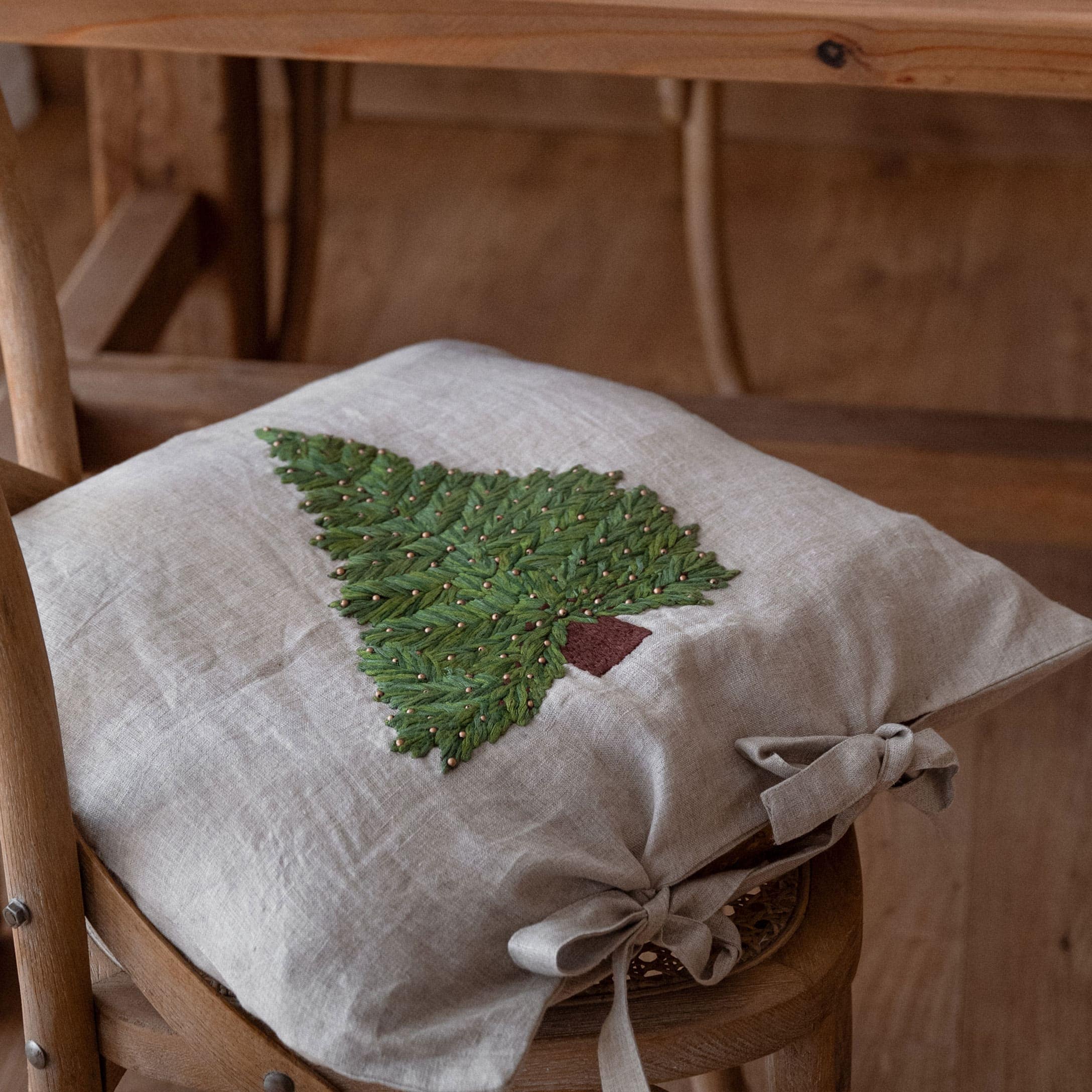 Leinen-Kissenbezug in Beige mit grünem Tannenbaum-Stick und Schleifen, Weihnachtsdeko