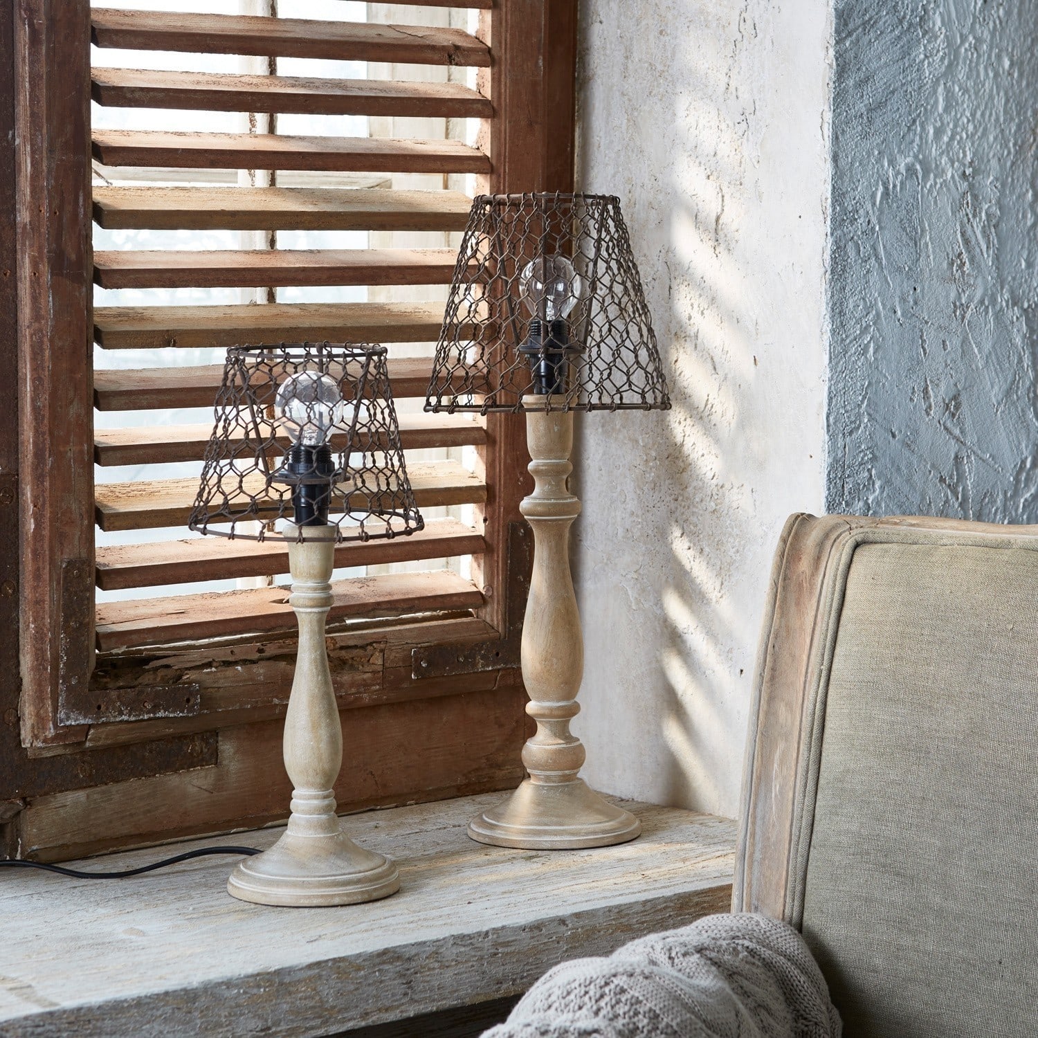 Holz-Tischlampen mit vintage Metalllampenschirmen auf Fensterbank in rustikalem Raum
