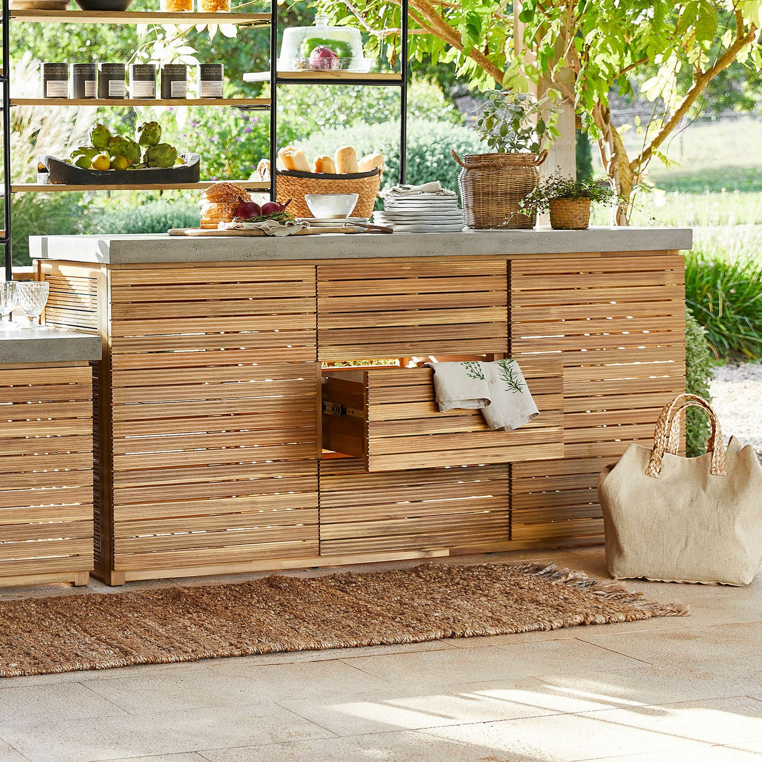 Outdoor-Küche mit Holzfronten und Betonarbeitsplatte auf Terrasse mit natürlichen Accessoires