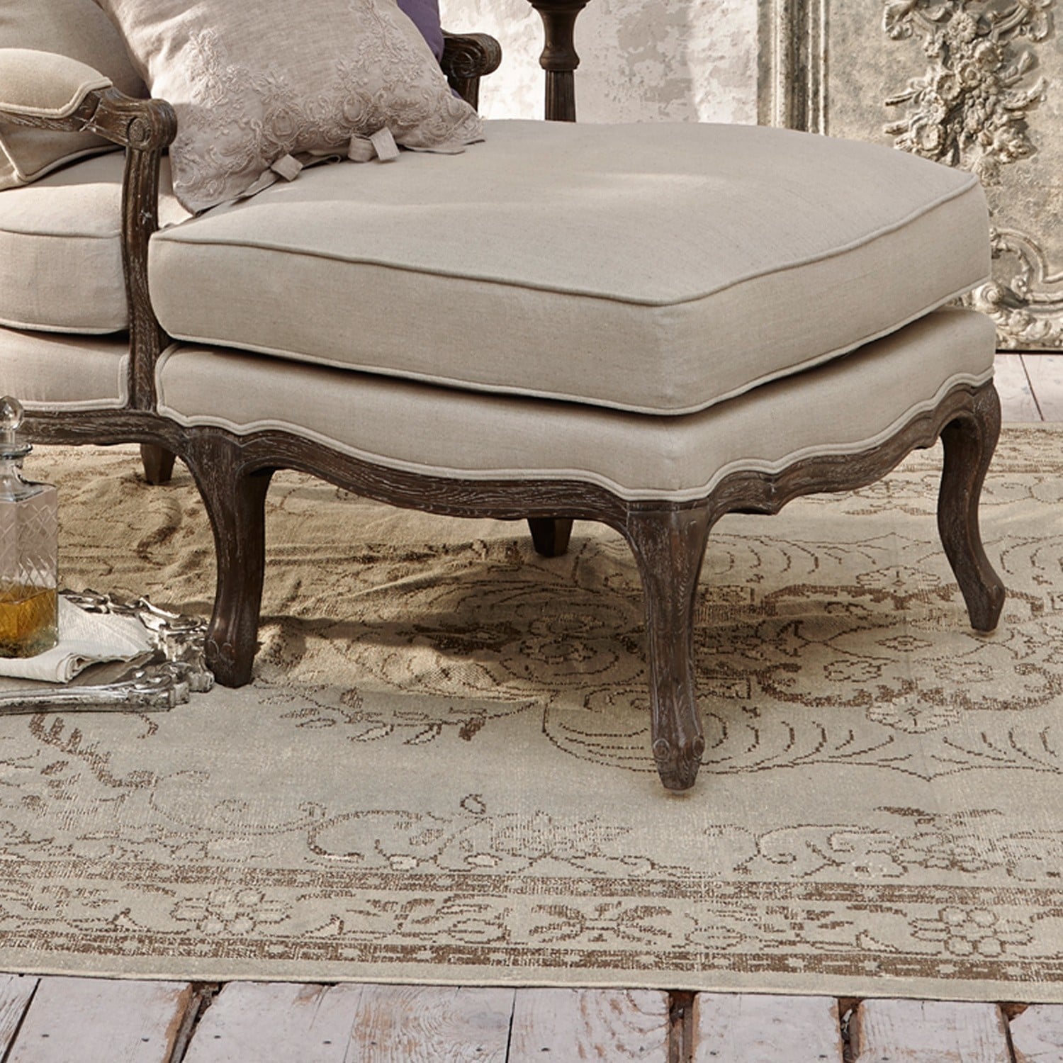 Beiger Stoffhocker mit dunklem, geschnitztem Holzrahmen auf Vintage-Teppich