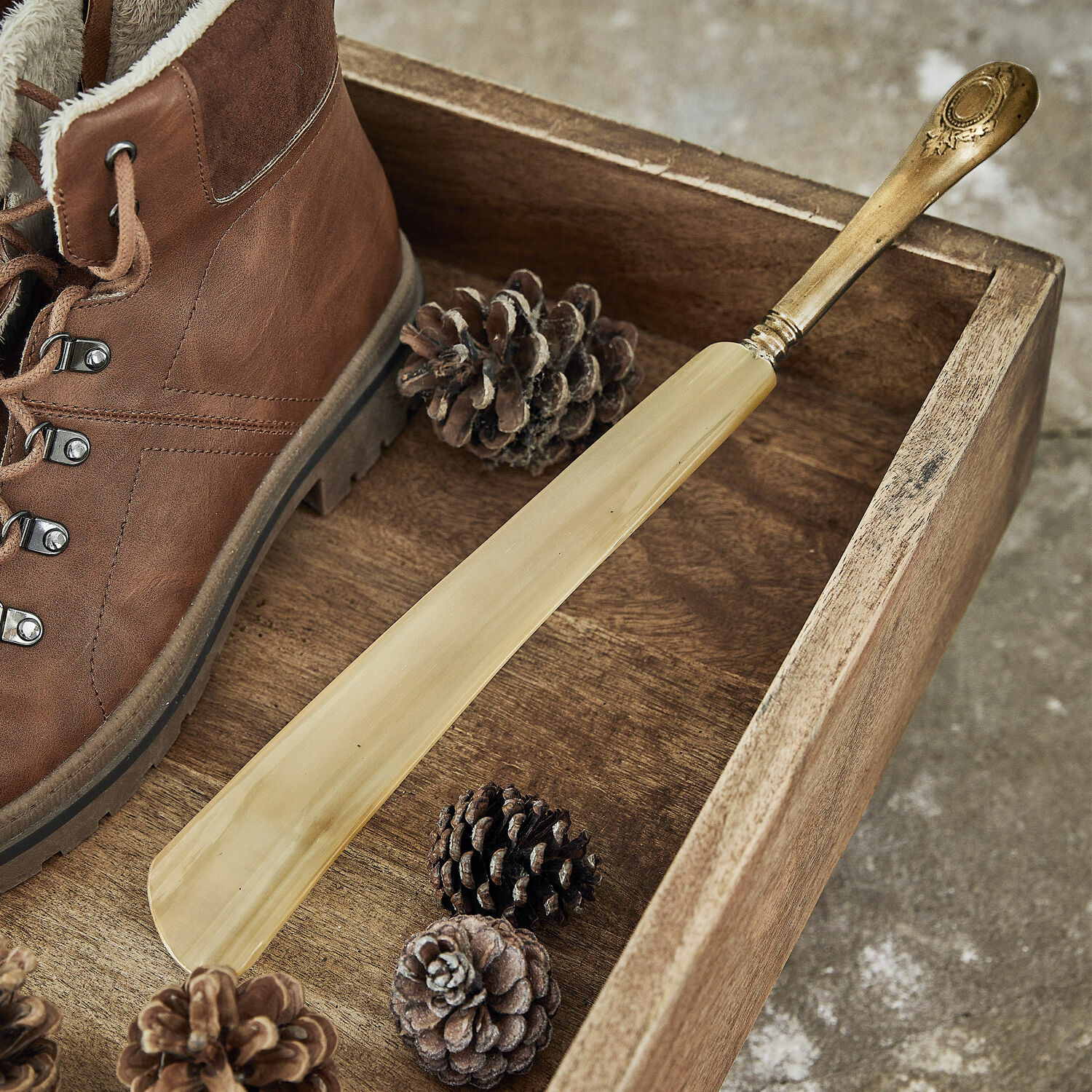 Schuhlöffel Charles Eleganter Schuhanzieher aus hellem Holz mit Messinggriff auf Holztablett neben braunem Schuh