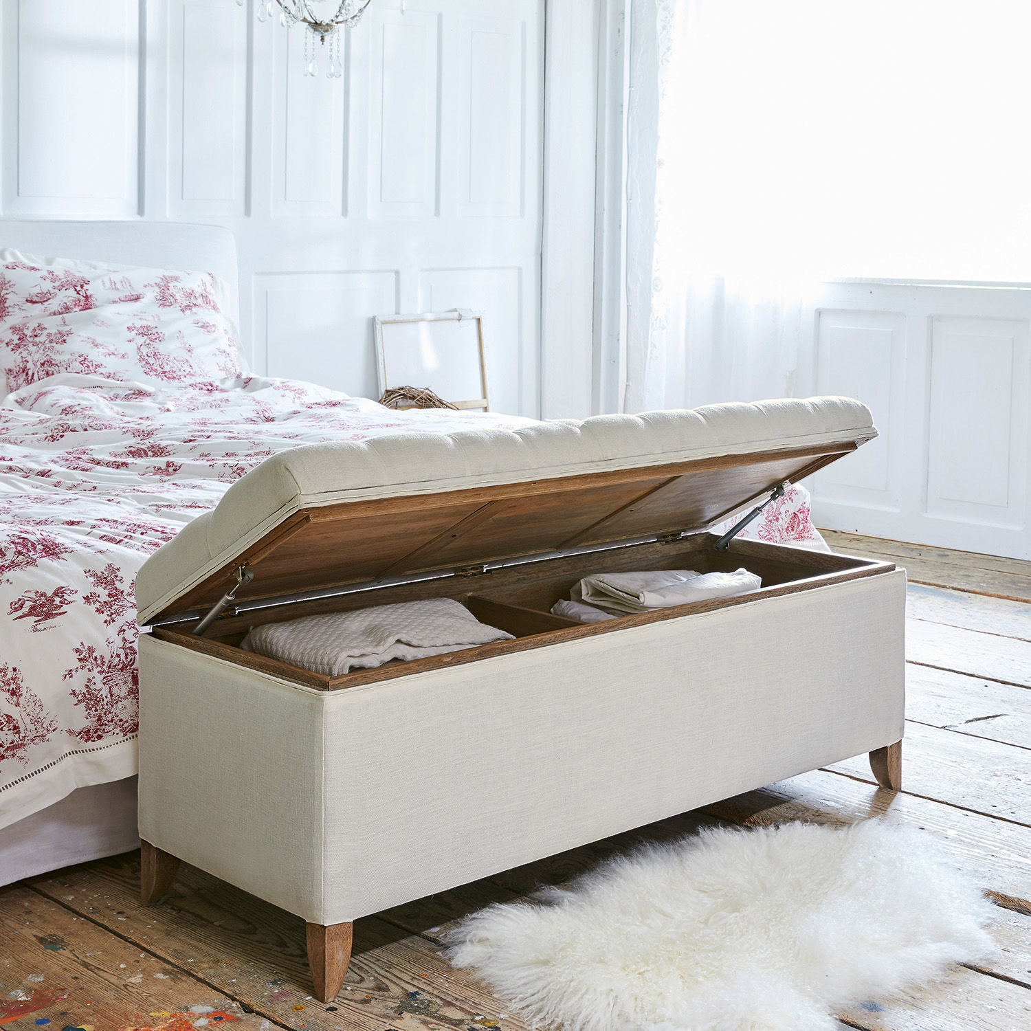 Beige gepolsterte Aufbewahrungsbank aus Holz in hellem Raum mit Holzboden und Teppich