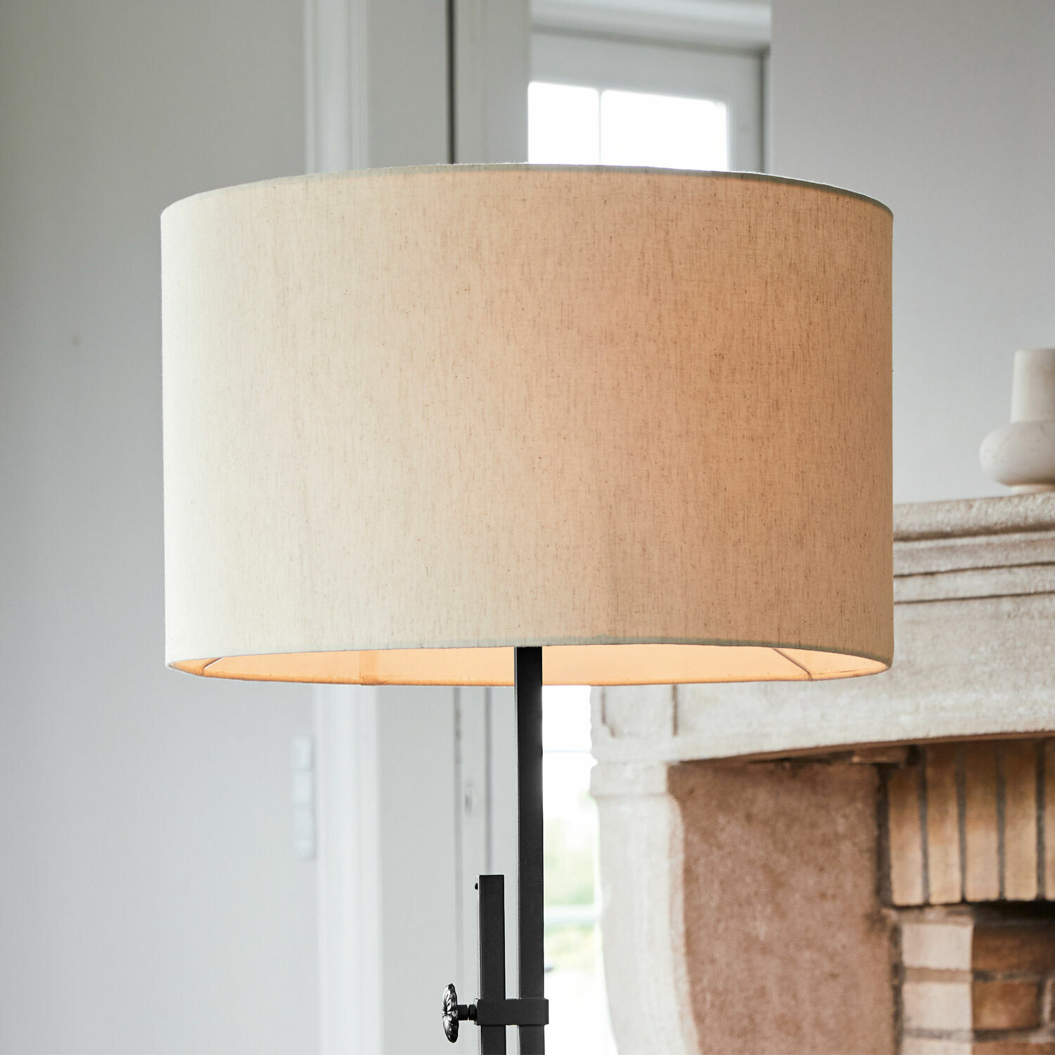 Stehlampe mit beigem Stoffschirm und schwarzem Metallgestell für Wohnzimmer