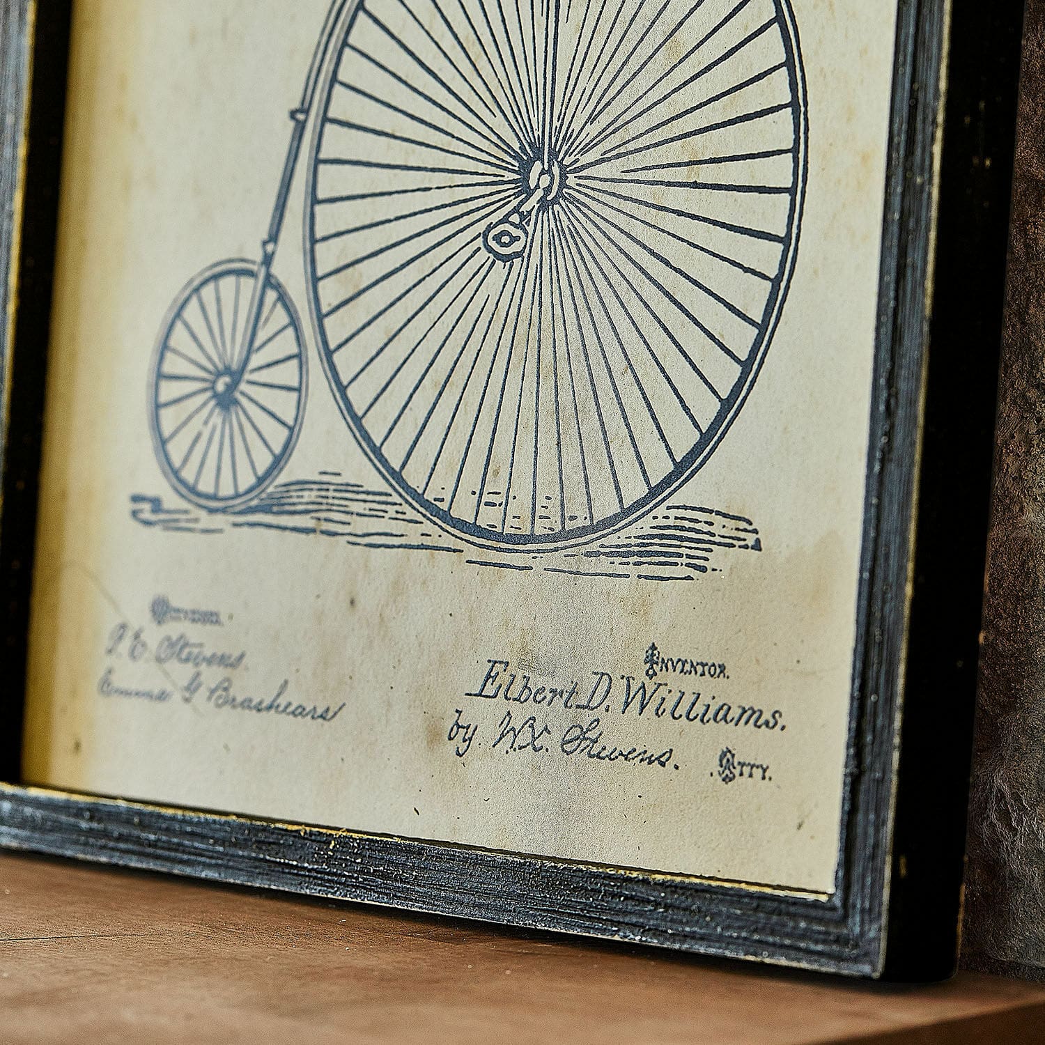 Vintage-Zeichnung eines alten Fahrrads mit großem Vorderrad in schwarzem Rahmen auf beigem Hintergrund