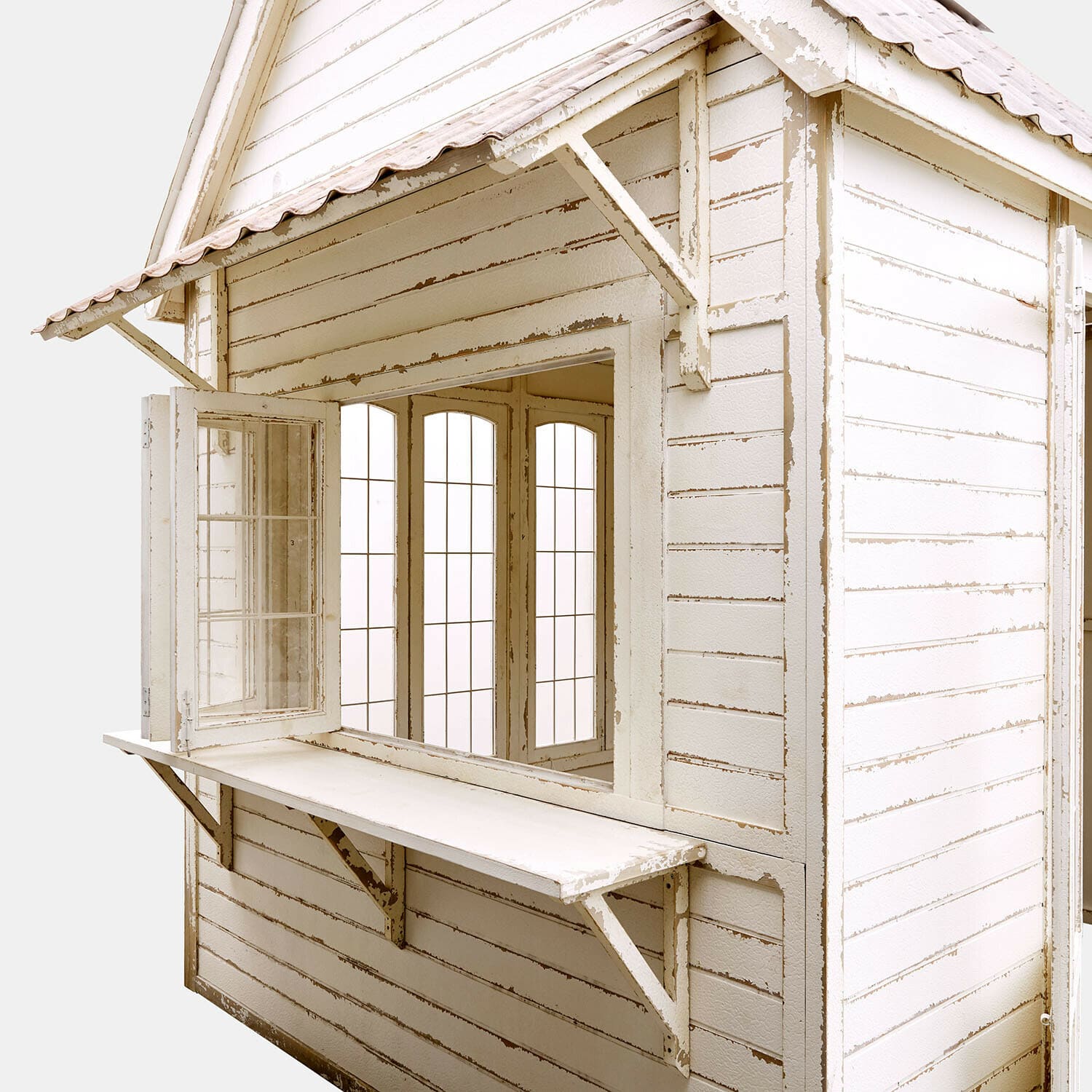 Weißes Holzhaus mit offenem Fenster und klappbarer Ablage, rustikaler Gartenstil