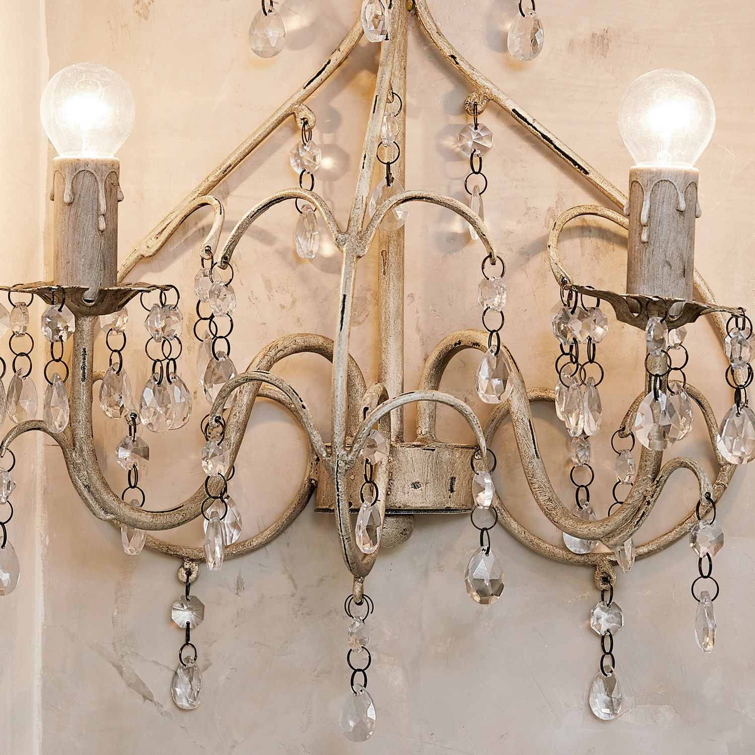 Wandlampe aus Metall in antikem Beige mit Kristallanhängern und sichtbaren Glühbirnen