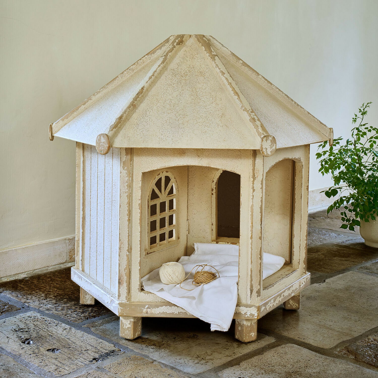 Katzen-Gartenhaus Alvérine Beige hölzernes Katzenhaus mit Fenstern und weißem Kissen auf Steinboden