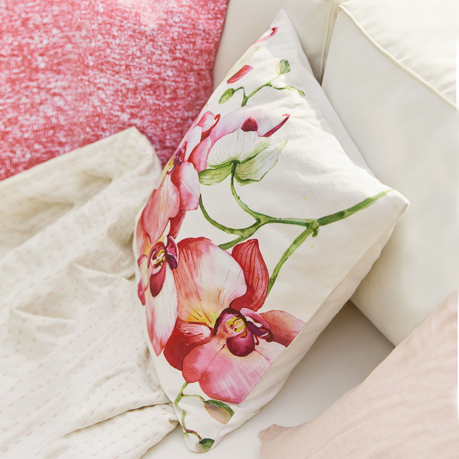 Dekoratives Baumwollkissen mit rosa Blumenmuster auf hellem Hintergrund für Wohnzimmer