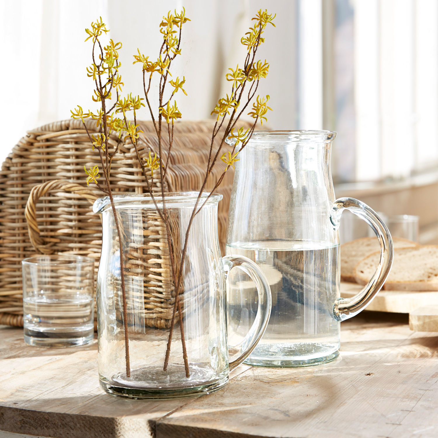 Krug 2er Set Janka Transparenter Glaskrug und Krug mit gelben Blütenzweigen auf hellem Holztisch