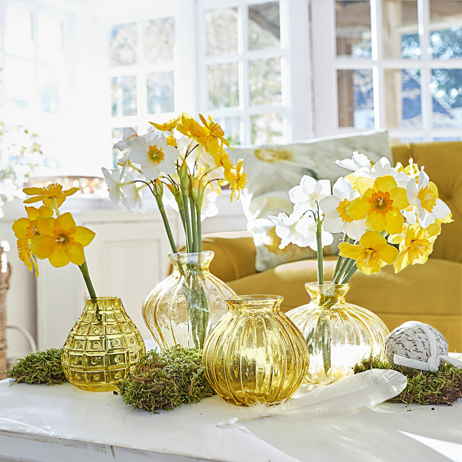 Deko-Blume 12er Set Misapina Set aus gelben Glasvasen mit gelb-weißen Blumen auf weißem Tisch in hellem Raum
