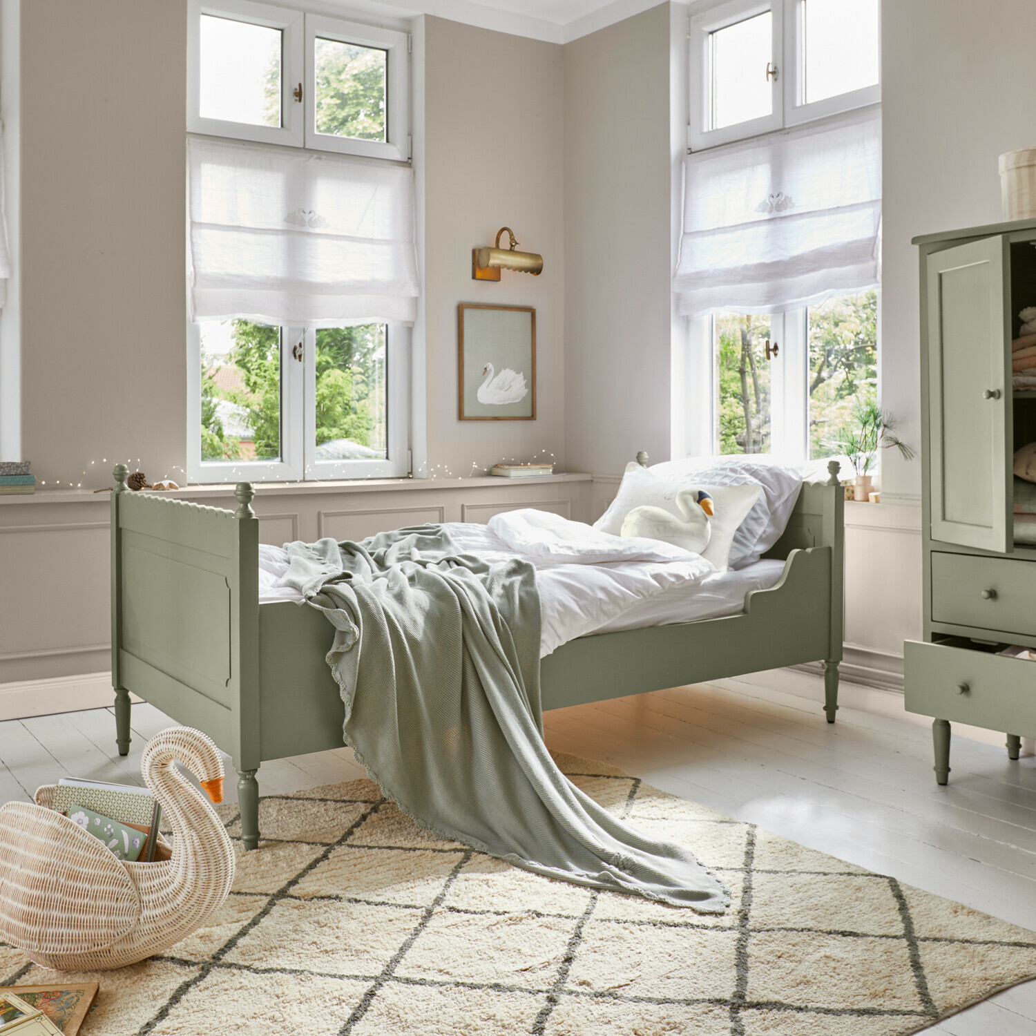 Schlafzimmer mit grünem Holzbett, weißer Bettwäsche und weicher Decke auf cremefarbenem Teppich mit Muster