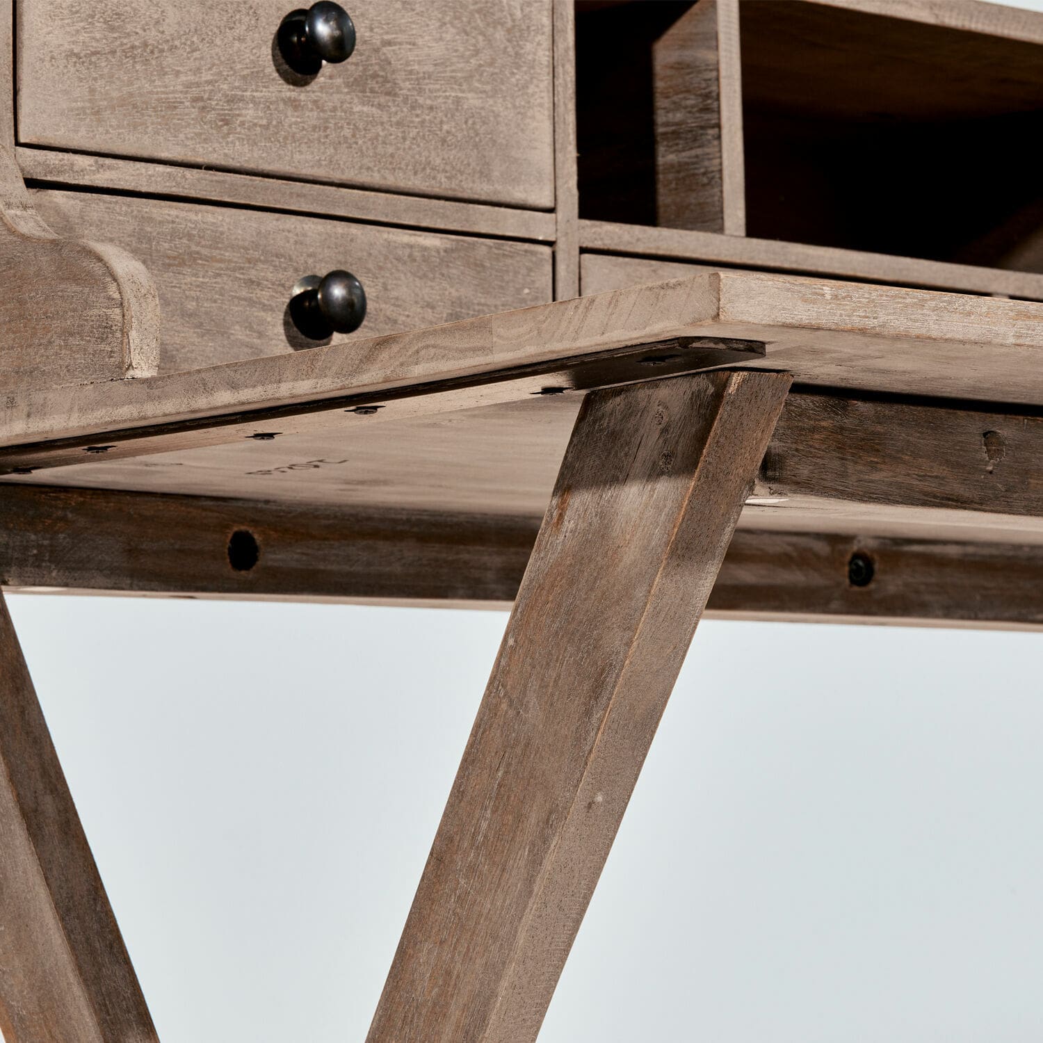 Schreibtisch aus naturfarbenem Holz mit Schubladen und schwarzen Metallknöpfen zur Aufbewahrung