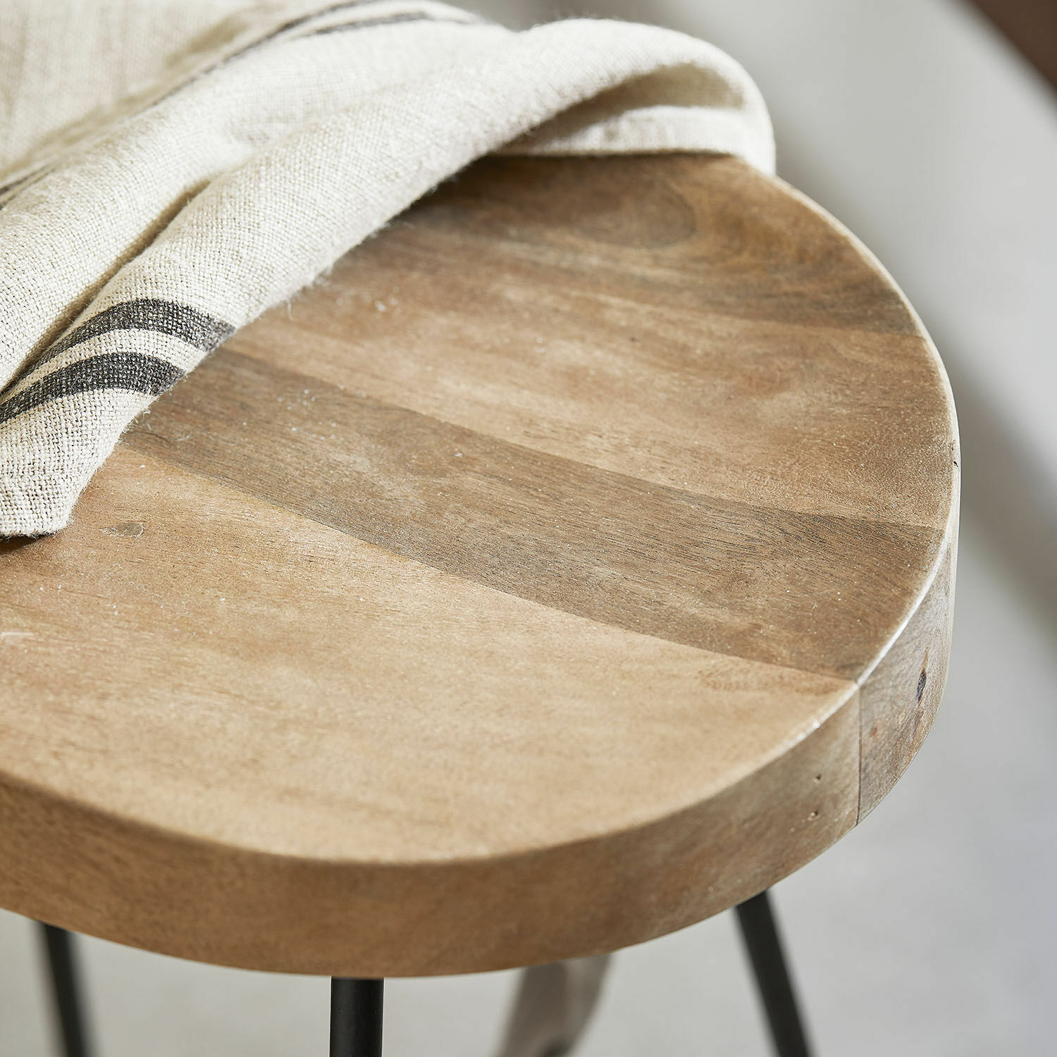 Runder Beistelltisch aus Mangoholz in Natur mit Metallbeinen und beigem Leinentuch