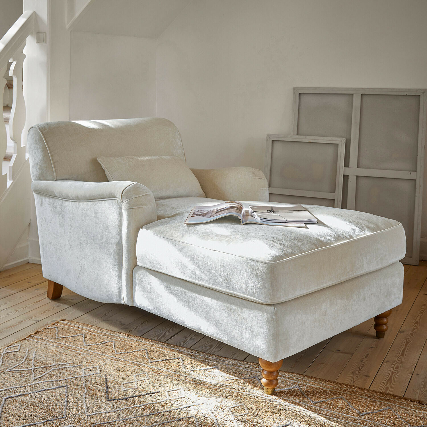 Chaiselongue Isa Beiger Sessel aus weichem Stoff mit Fußstütze und Holzbeinen in hellem Wohnzimmer