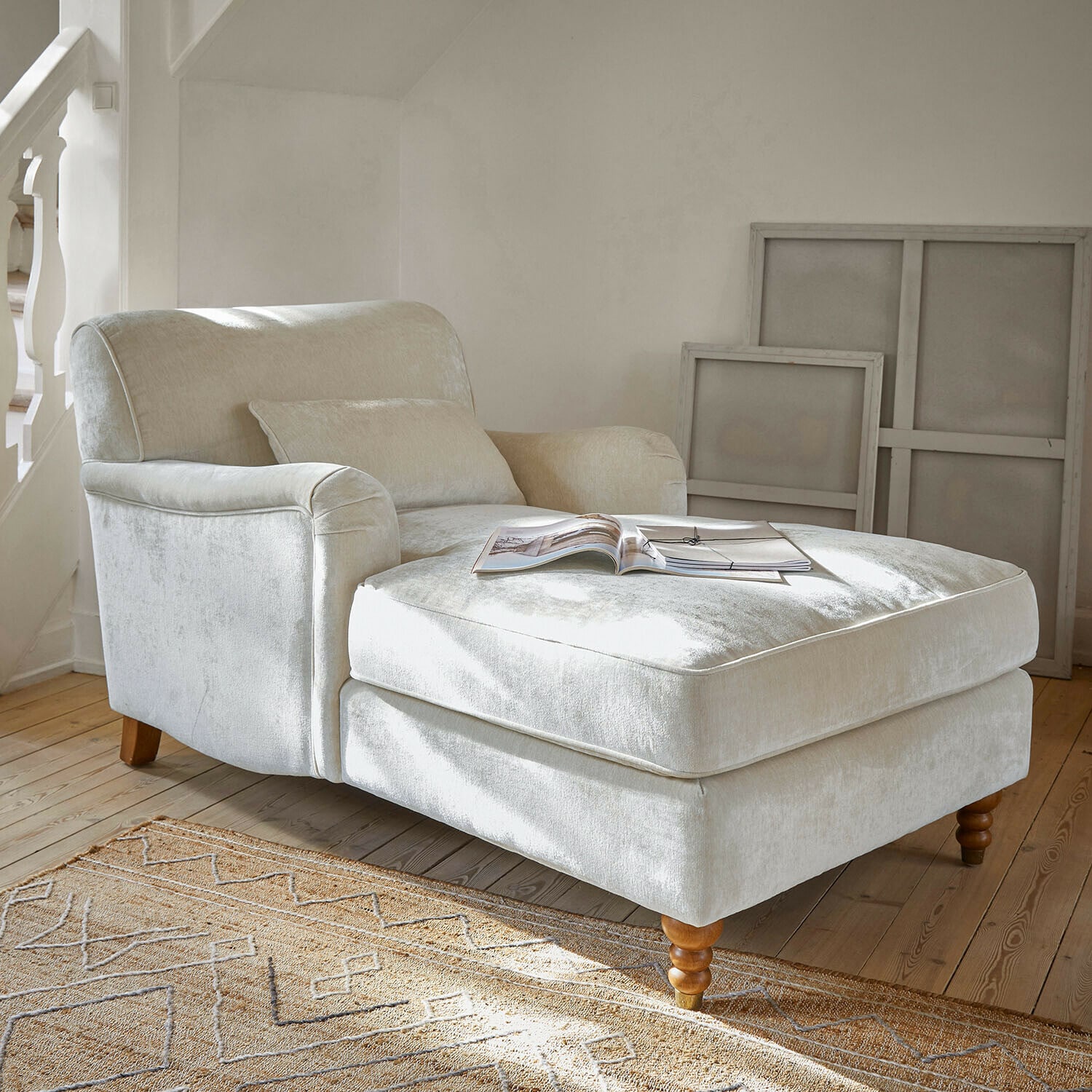 Chaiselongue Isa Beiger Sessel aus weichem Stoff mit Fußstütze und Holzbeinen in hellem Wohnzimmer