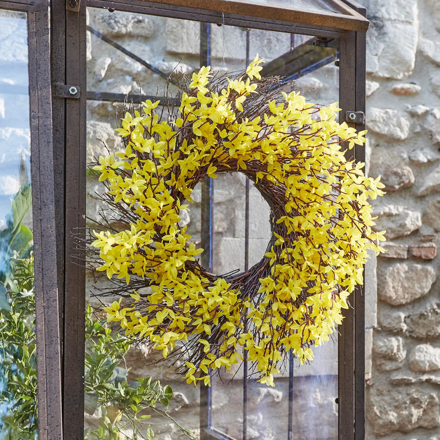 Frühlingskranz mit gelben Blüten und Zweigen auf Metallrahmen, dekorative Wohn- und Gartendekoration