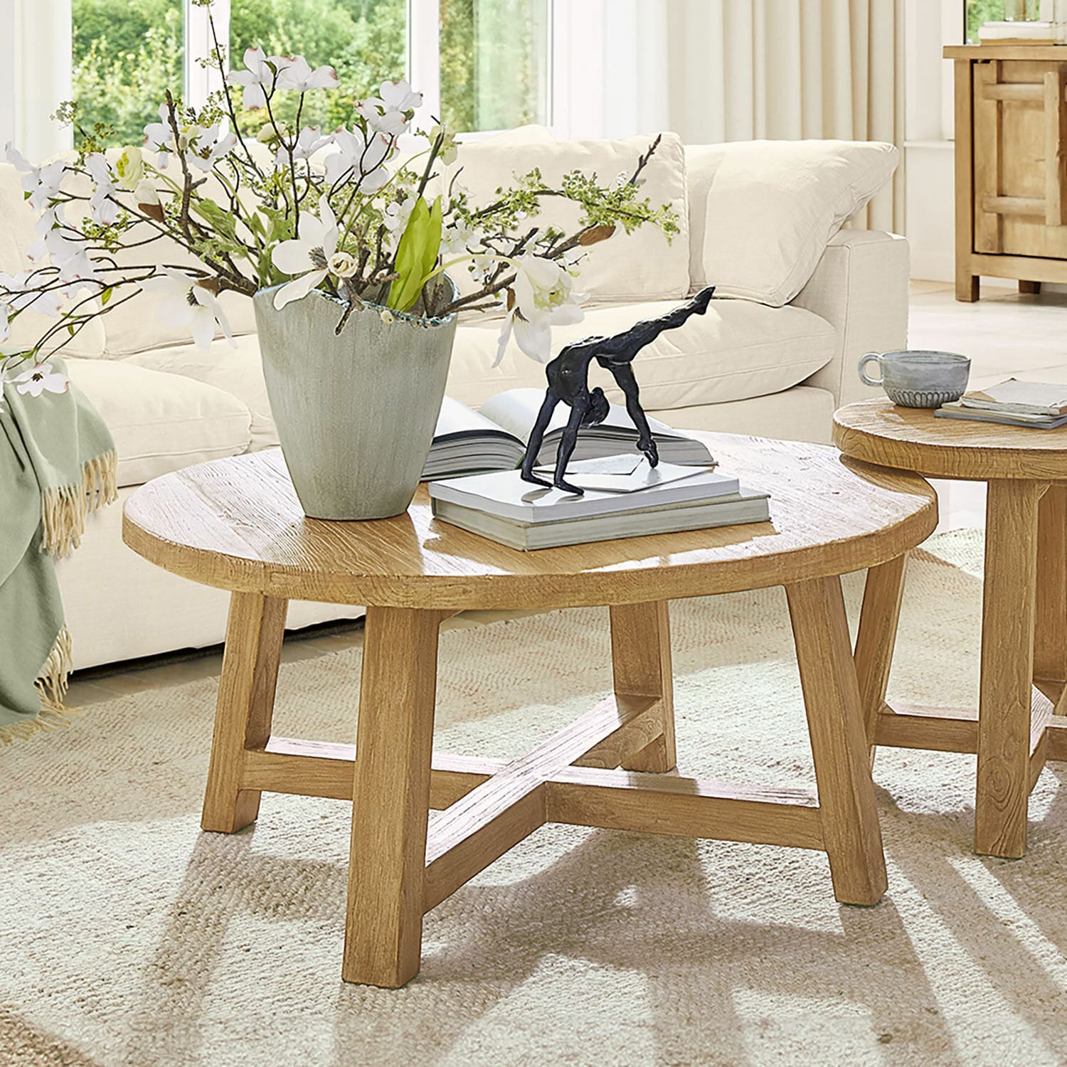 Couchtisch Gorivel Runder Couchtisch aus naturfarbenem Eichenholz mit Dekoration und Büchern im Wohnzimmer
