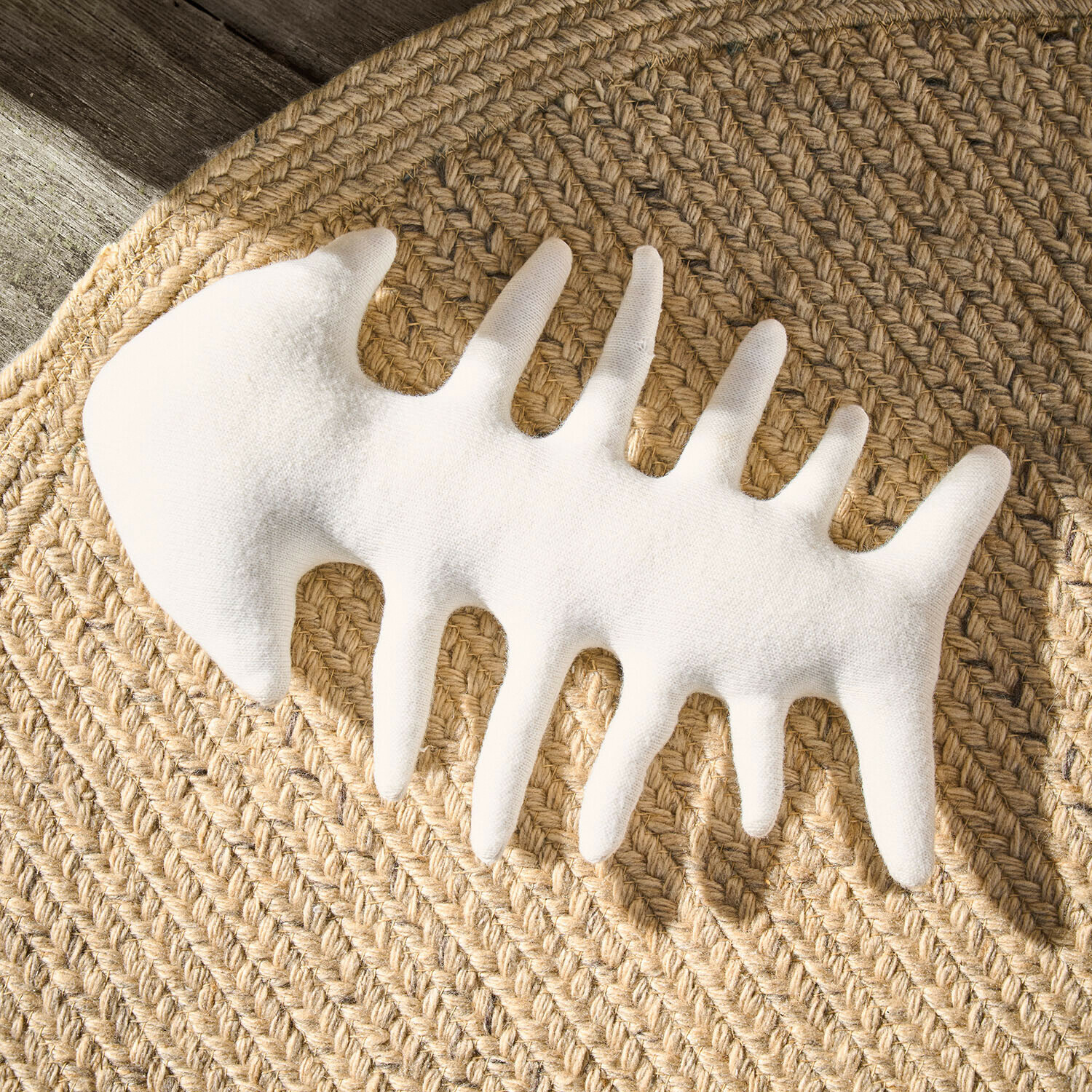 Weiße Fischgräten-Dekoration aus Stoff auf geflochtenem Jute-Teppich