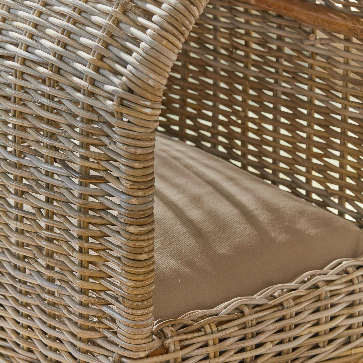 Rattanstuhl mit beigem Kissen, natürlicher Werkstoff und Farbe, Möbelstück für Wohn- oder Gartenbereich