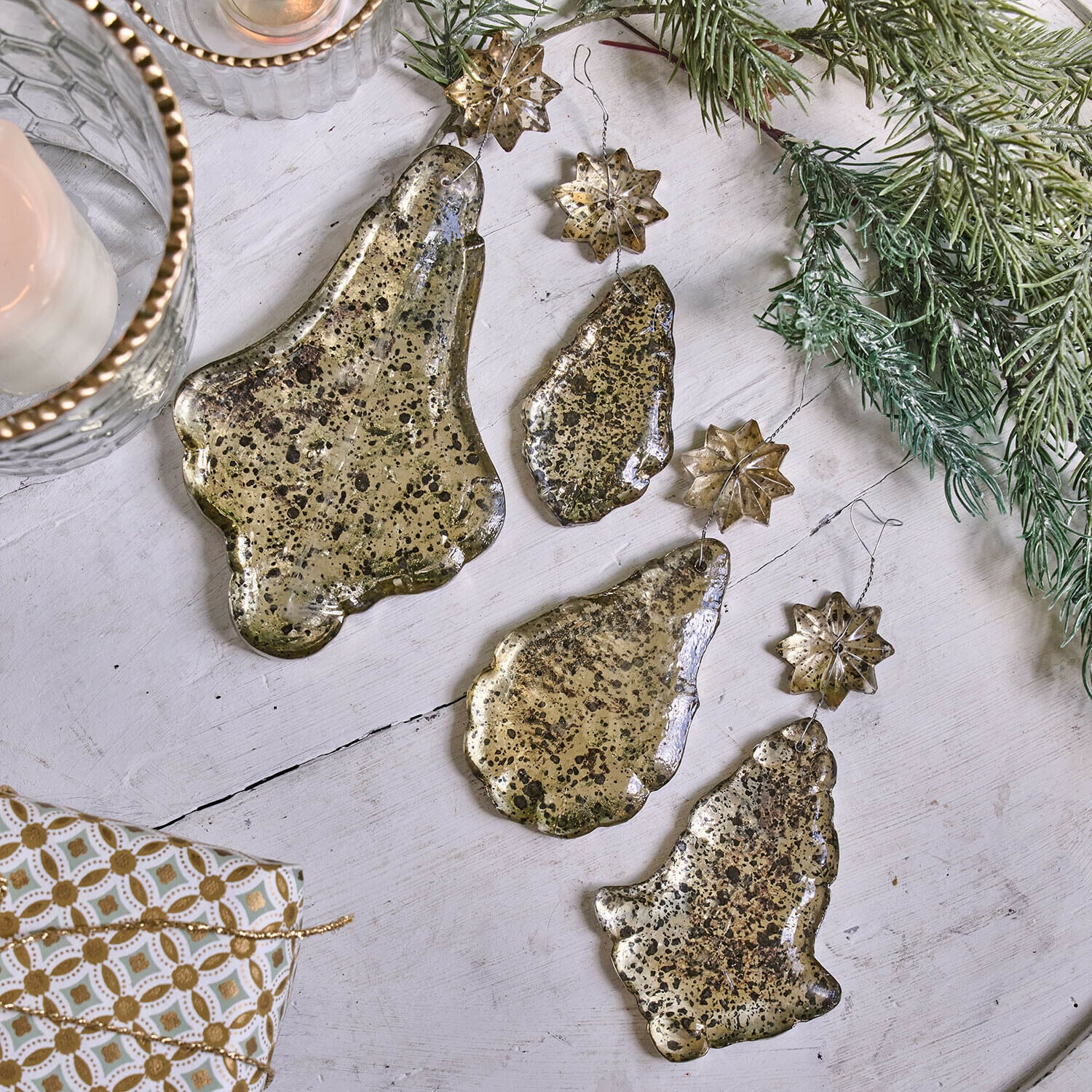 Weichnachtsschmuck 4er Set Dolenza Set goldfarbiger Metall-Weihnachtsanhänger in Glocken- und Sternform auf weißem Hintergrund