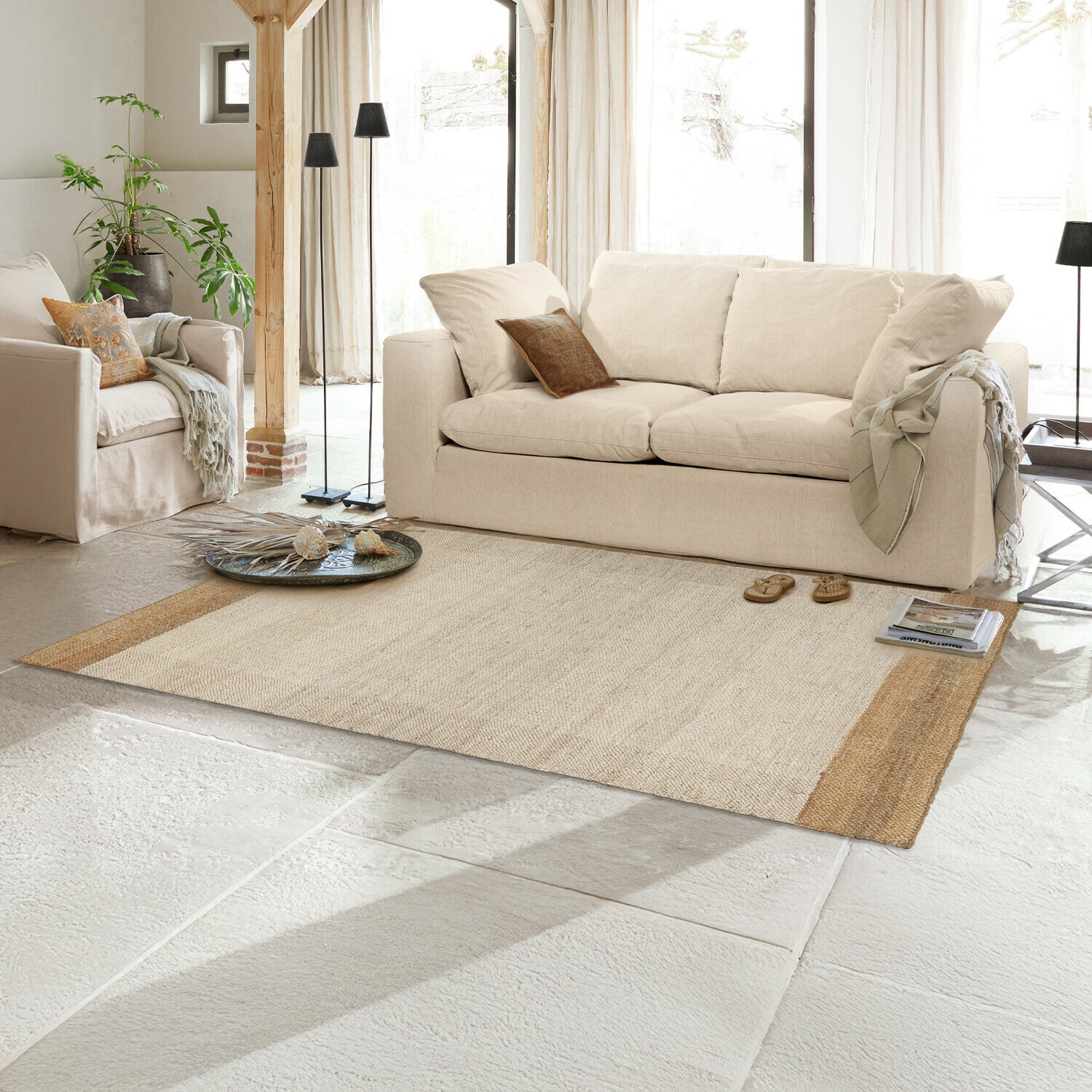 Teppich Estelune Beiger Naturfaser-Teppich im hellen Wohnzimmer mit cremefarbener Couch und Dekorationen