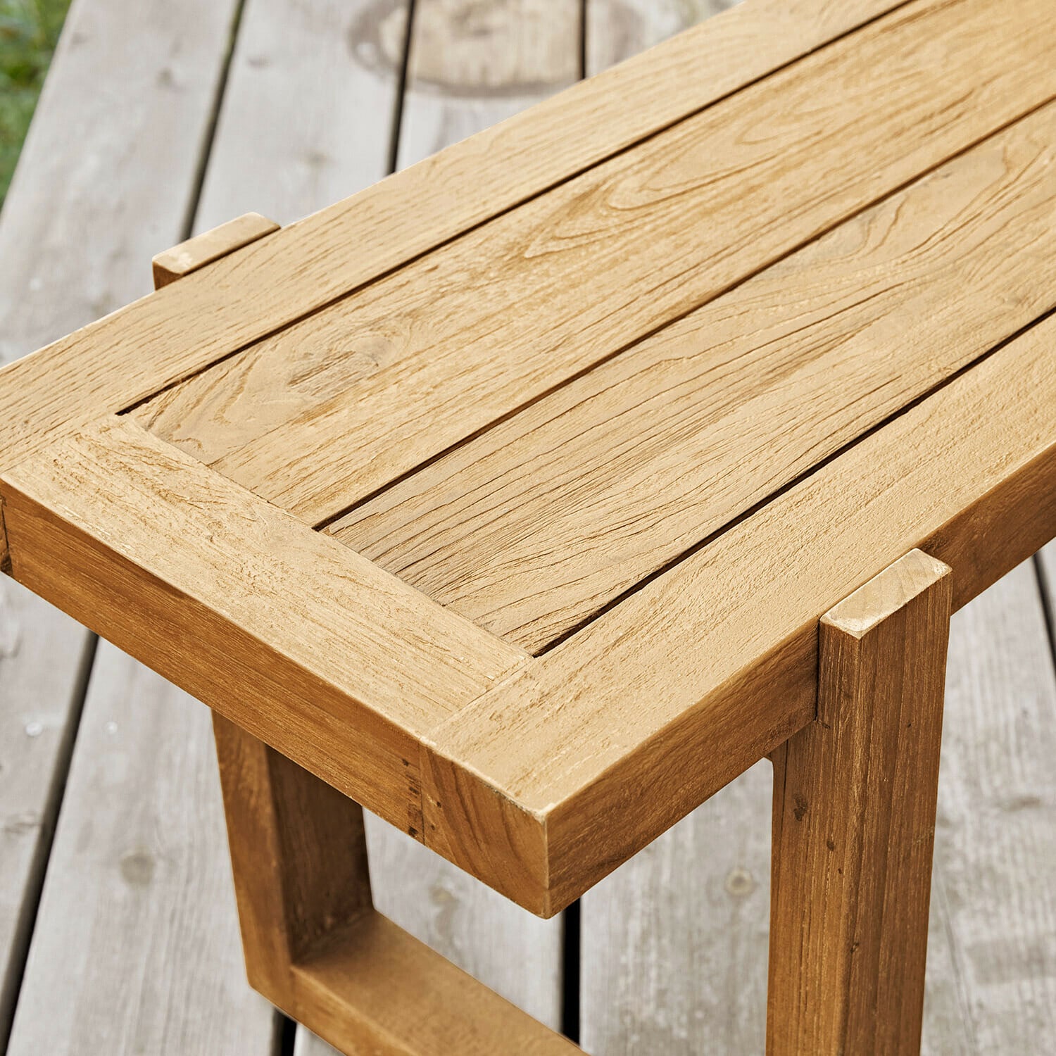 Heller Teakholz-Tisch auf Terrasse, stabiler Gartentisch mit natürlicher Holzmaserung
