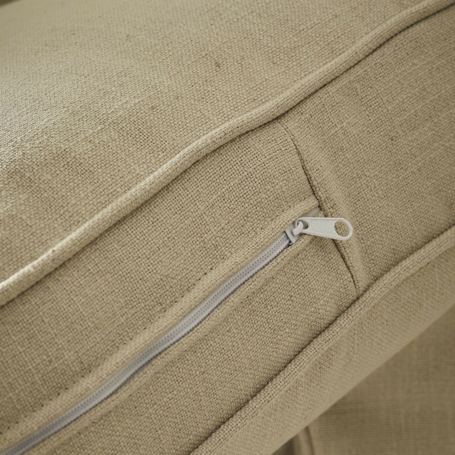 Beige Stoff mit Reißverschluss an einem Kissen aus natürlichem Material für Wohnraumdeko
