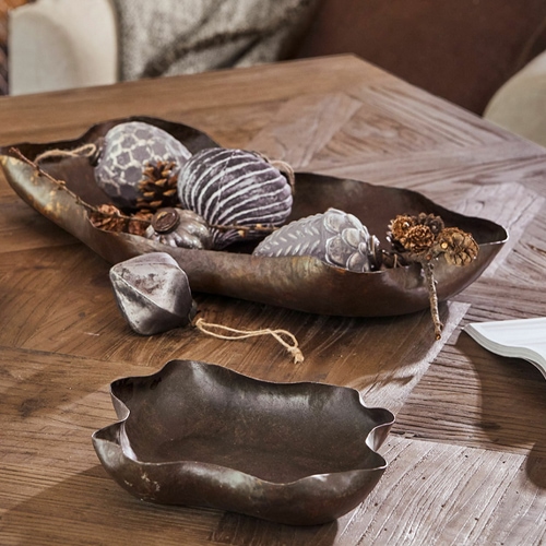 Dekorative braune Metallschale und Schüssel auf einem Holztisch im Wohnzimmer