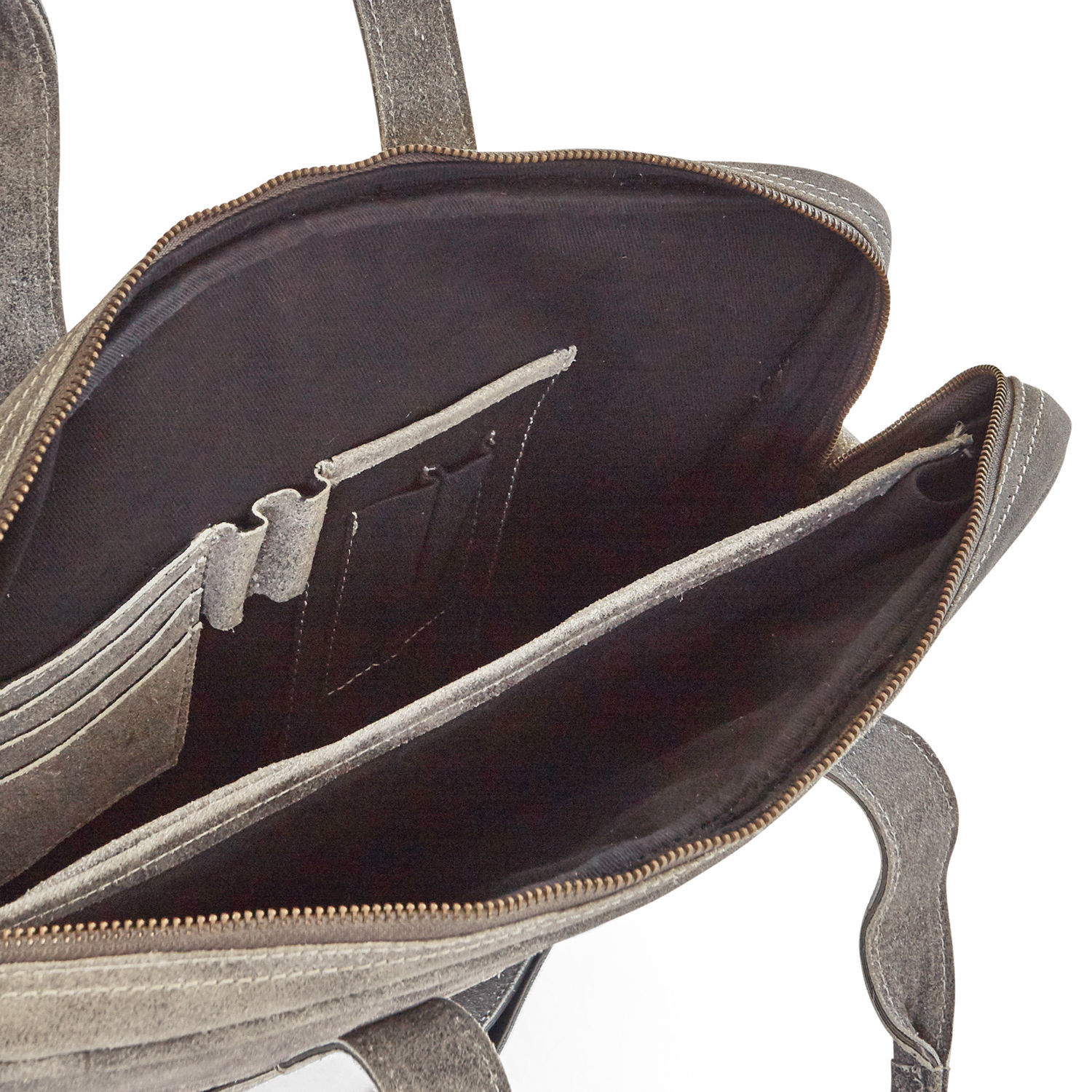 Innenansicht einer grauen Wildledertasche mit mehreren Fächern und Reißverschluss für Zubehör