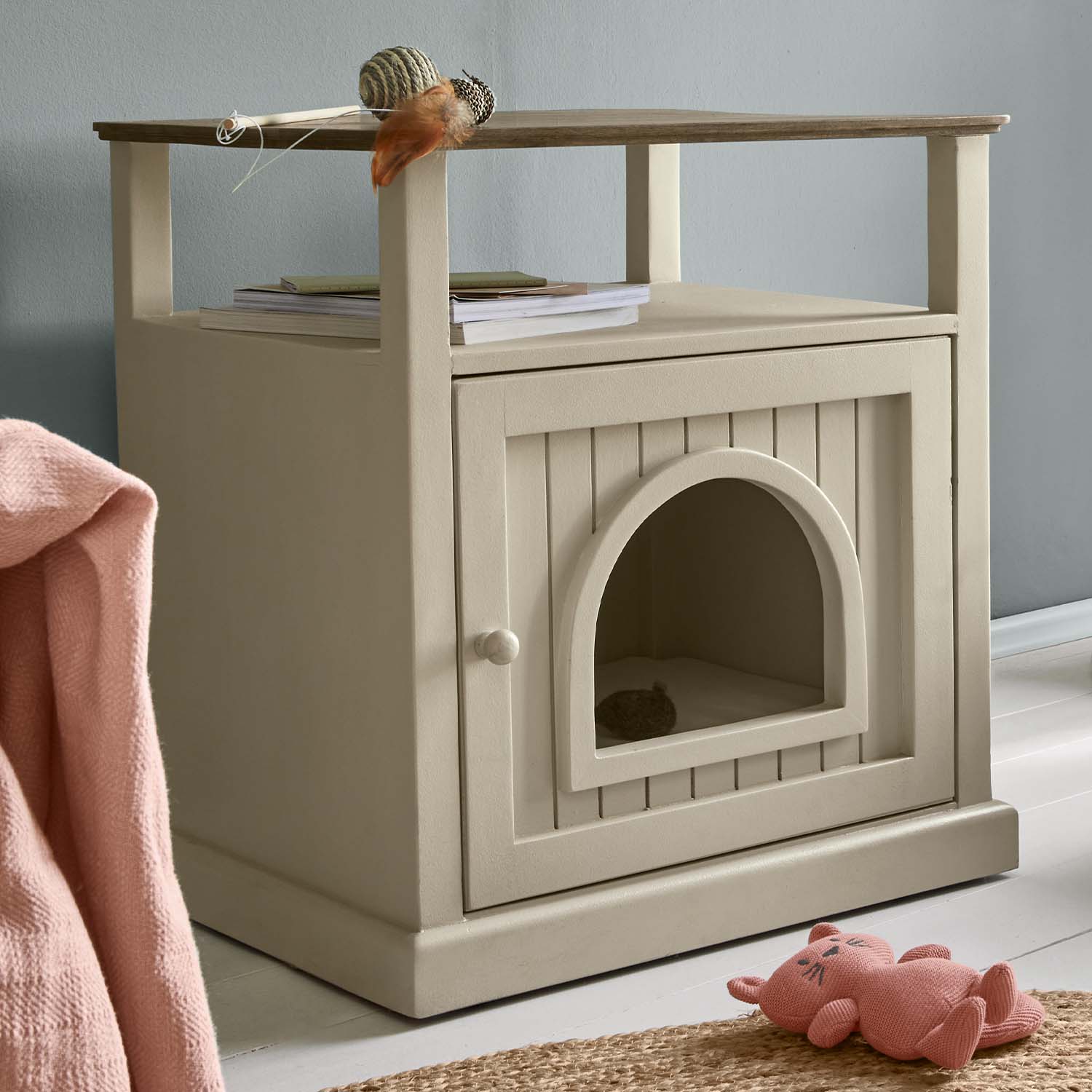 Beiger Holzschrank mit bogenförmiger Öffnung, dient als Katzenhaus und praktischer Beistelltisch