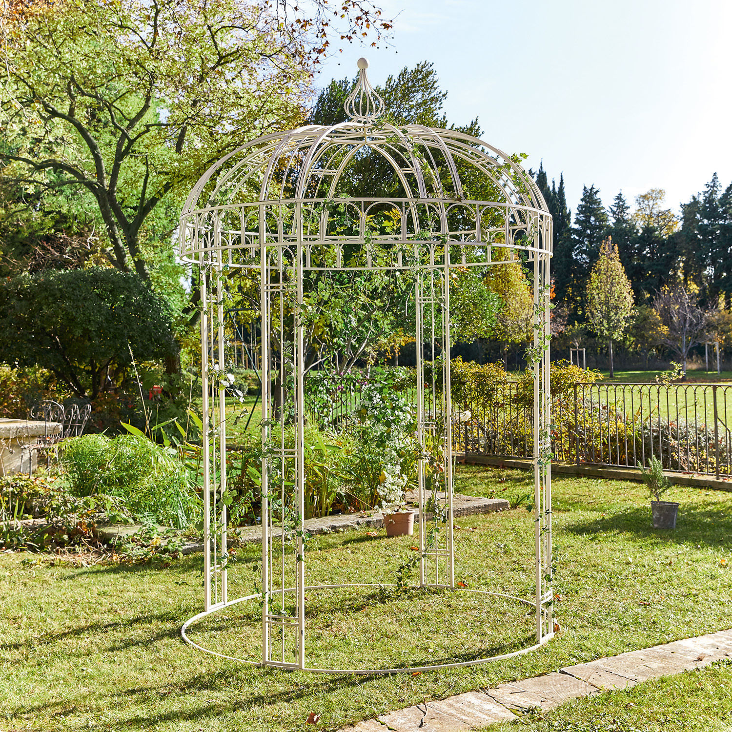 Weiße Metall-Gartenlaube mit dekorativem Dach, ideal für Kletterpflanzen im Garten