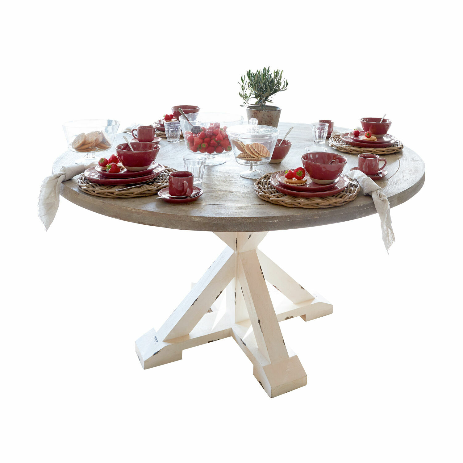 Runder Holztisch mit weißem Gestell, gedeckt mit rotem Geschirr und Erdbeeren zum Frühstück