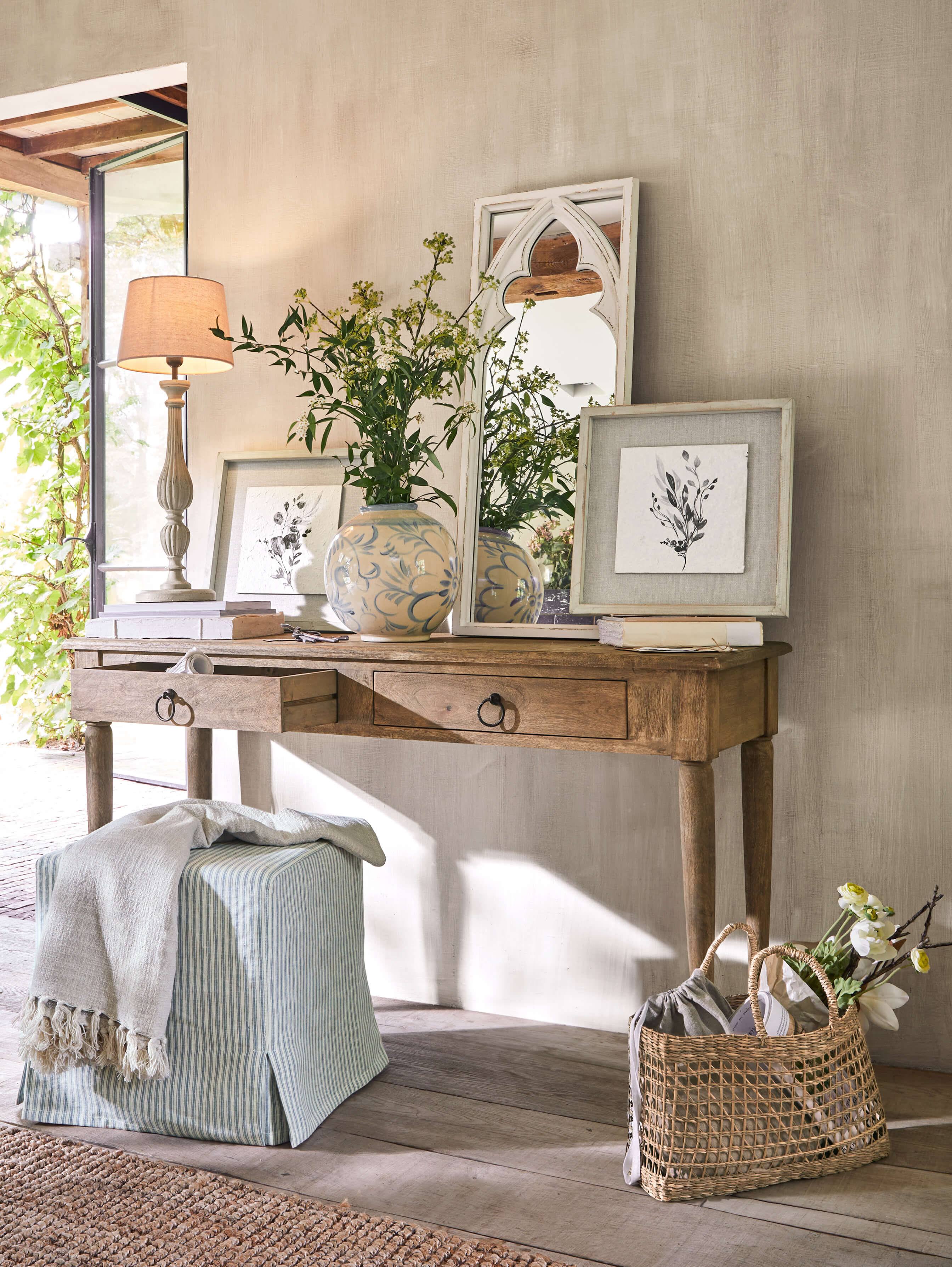 Holzschreibtisch mit zwei Schubladen, dekoriert mit Lampe, Vase und Spiegel in hellem Raum